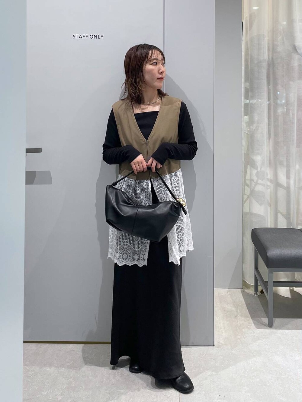 ブラック系のスカート、ブラック系のショルダーバッグ、ブラウン系のその他アウターを着用したレディースの春コーディネートの2枚目の写真