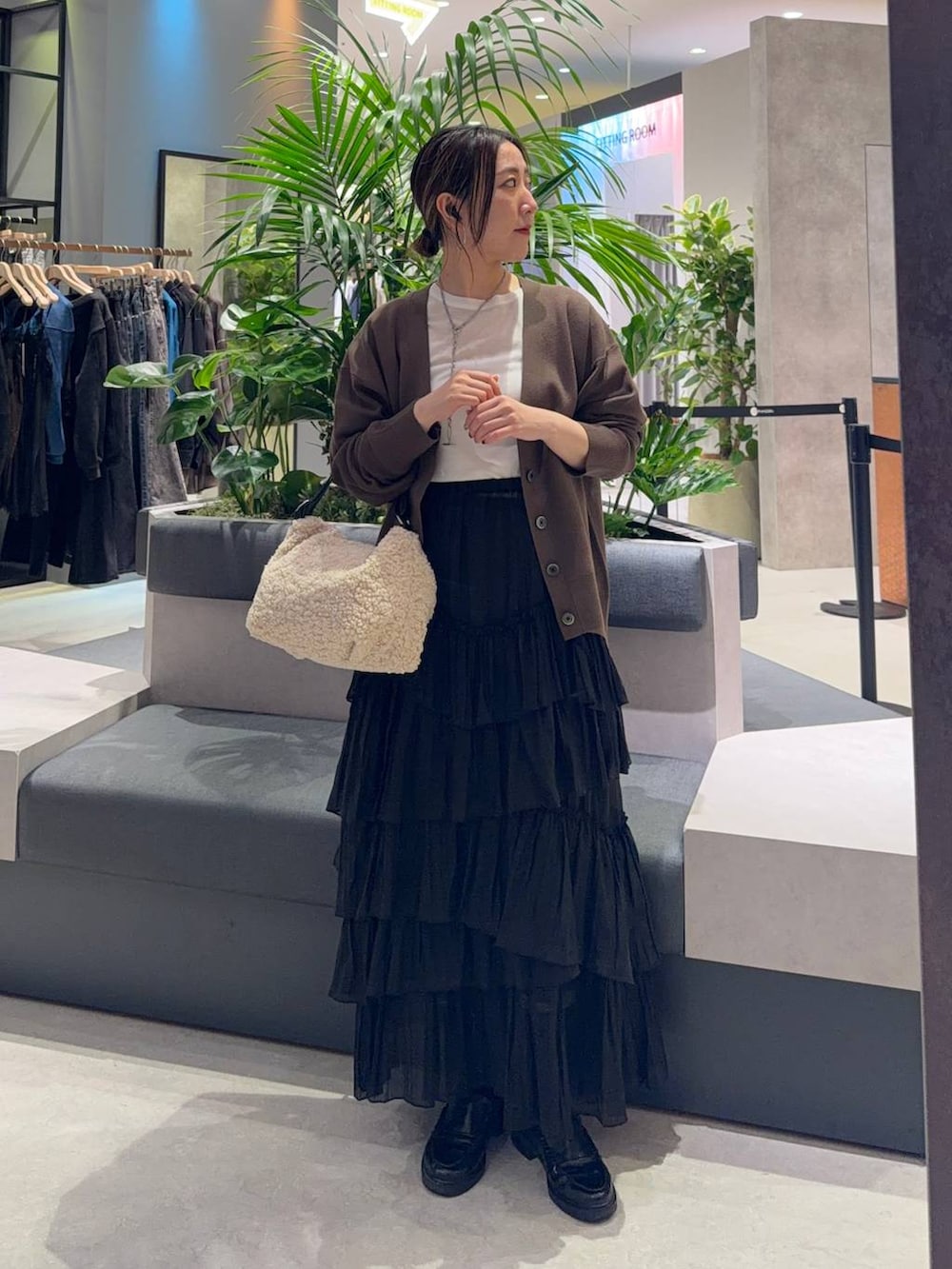 ホワイト系のショルダーバッグ、ホワイト系のTシャツ/カットソー、ブラック系のスカートを着用したレディースの秋コーディネートの2枚目の写真