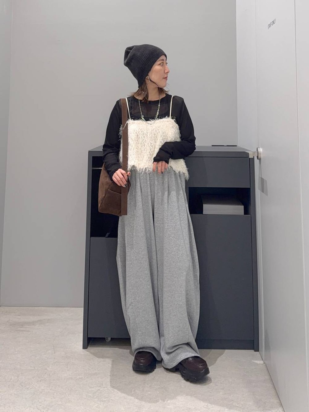 グレー系のスウェットパンツ、ブラック系のTシャツ/カットソー、ブラウン系のローファーを着用したレディースの夏コーディネートの3枚目の写真