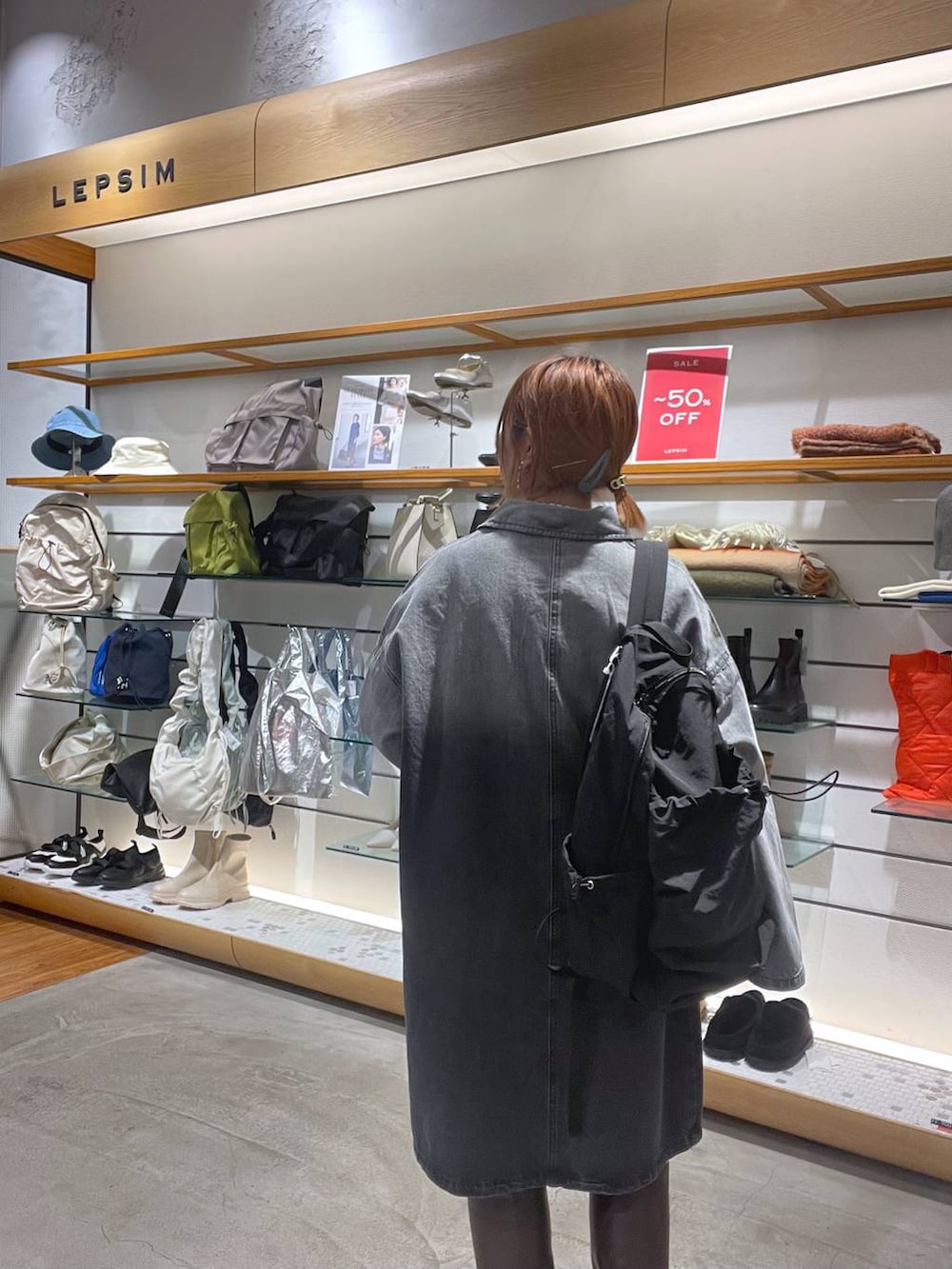 ブラウン系のブーツ、ブラック系のバックパック/リュック、ホワイト系のニット/セーターを着用したレディースの春コーディネートの4枚目の写真