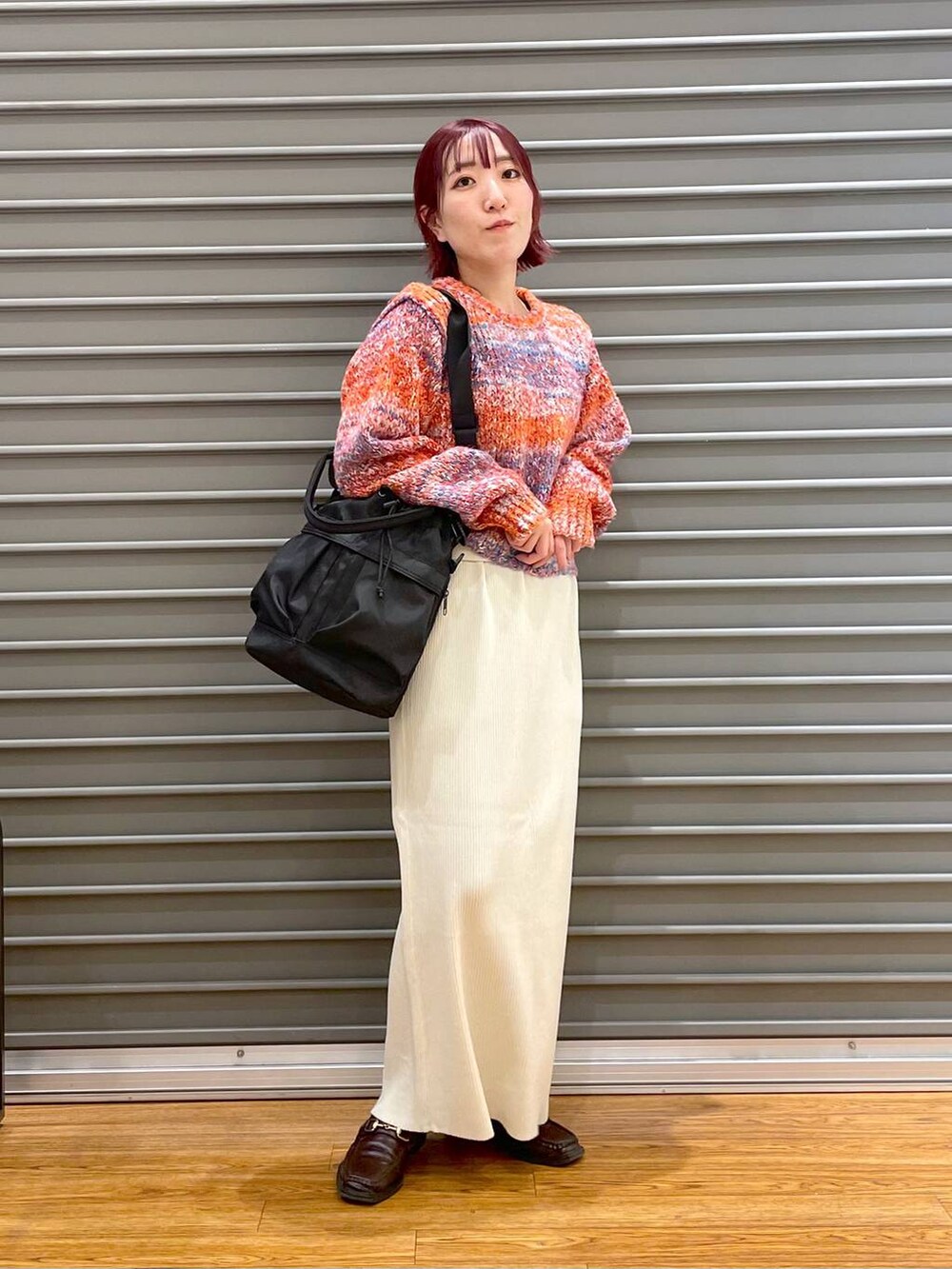 レッド系のニット/セーター、ブラック系のショルダーバッグ、ホワイト系のマタニティウェア/グッズを着用したレディースの冬コーディネートの2枚目の写真