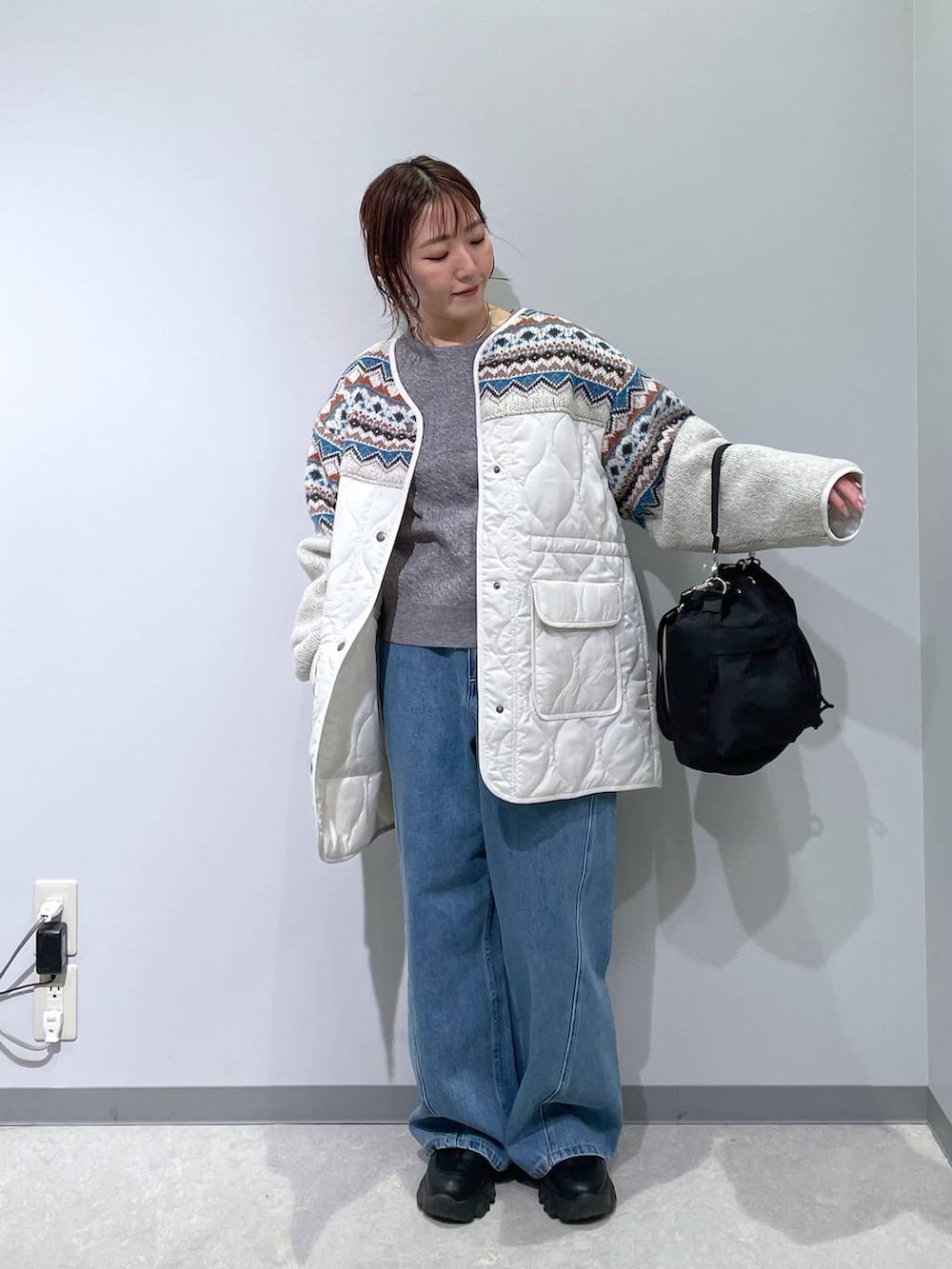 ブラック系のショルダーバッグ、グレー系のニット/セーター、ベージュ系のブルゾンを着用したレディースの冬コーディネートの3枚目の写真