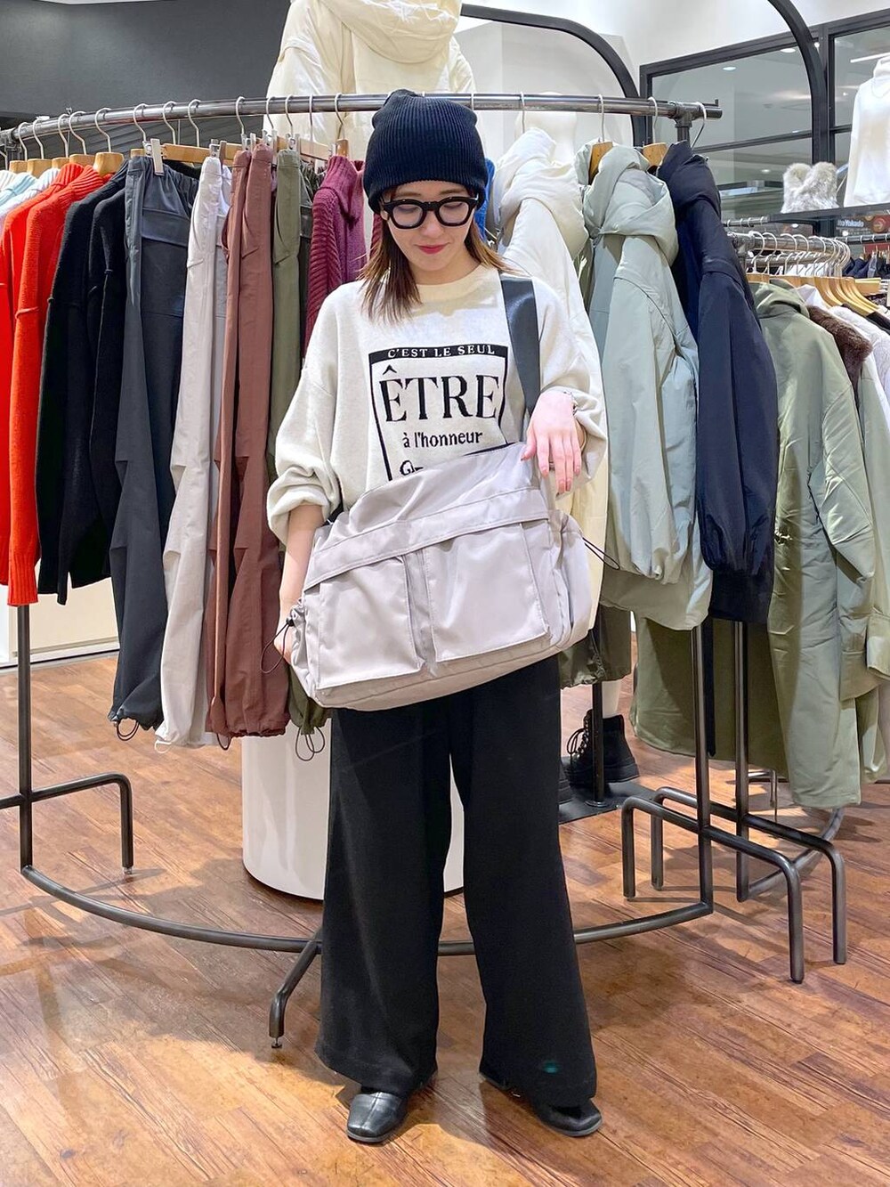 ホワイト系のニット/セーター、ブラック系のその他パンツ、グレー系のショルダーバッグを着用したレディースの冬コーディネートの2枚目の写真