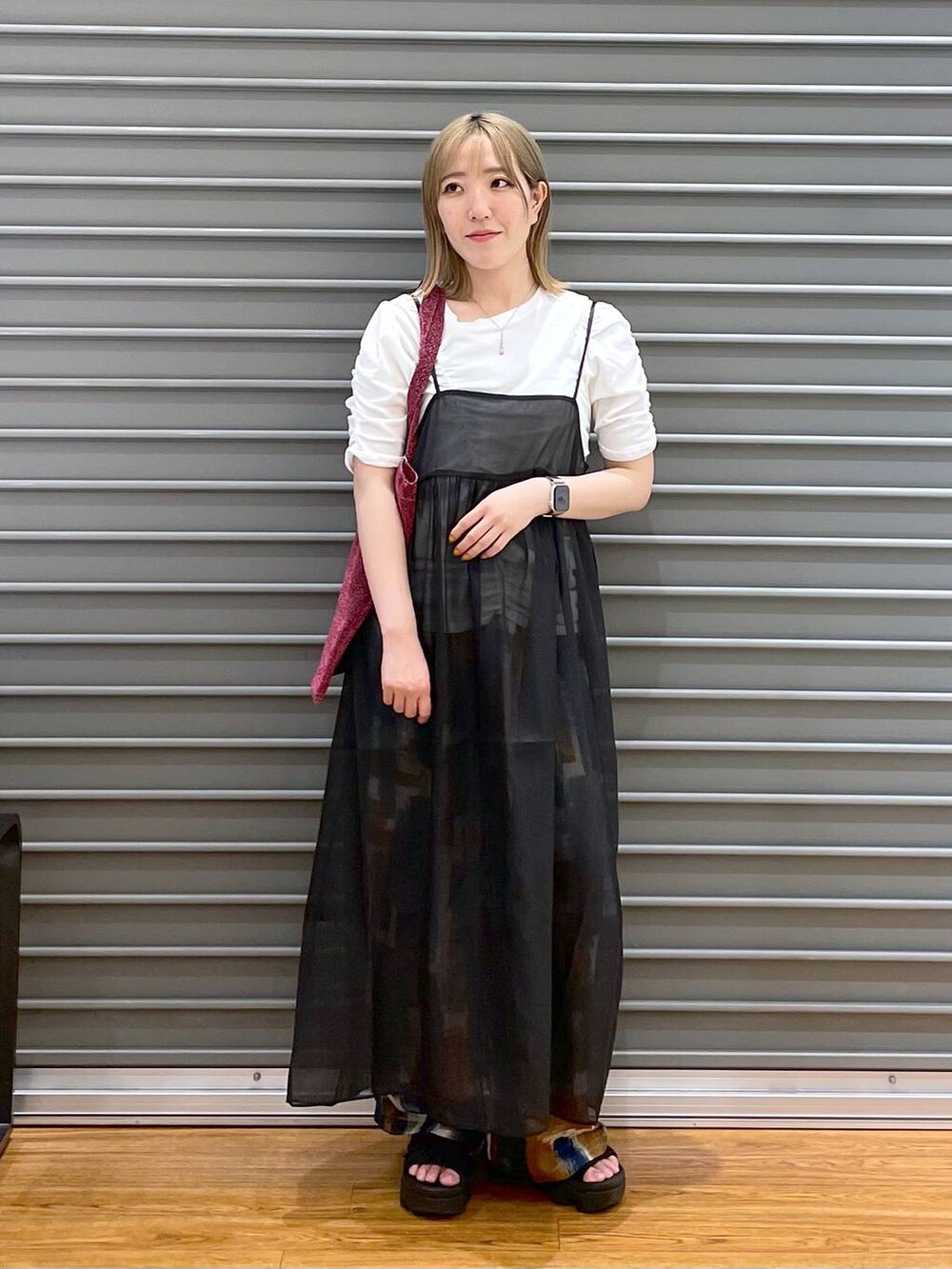 ピンク系のトートバッグ、ブラック系のワンピース、ブルー系のその他パンツを着用したレディースの夏コーディネートの3枚目の写真