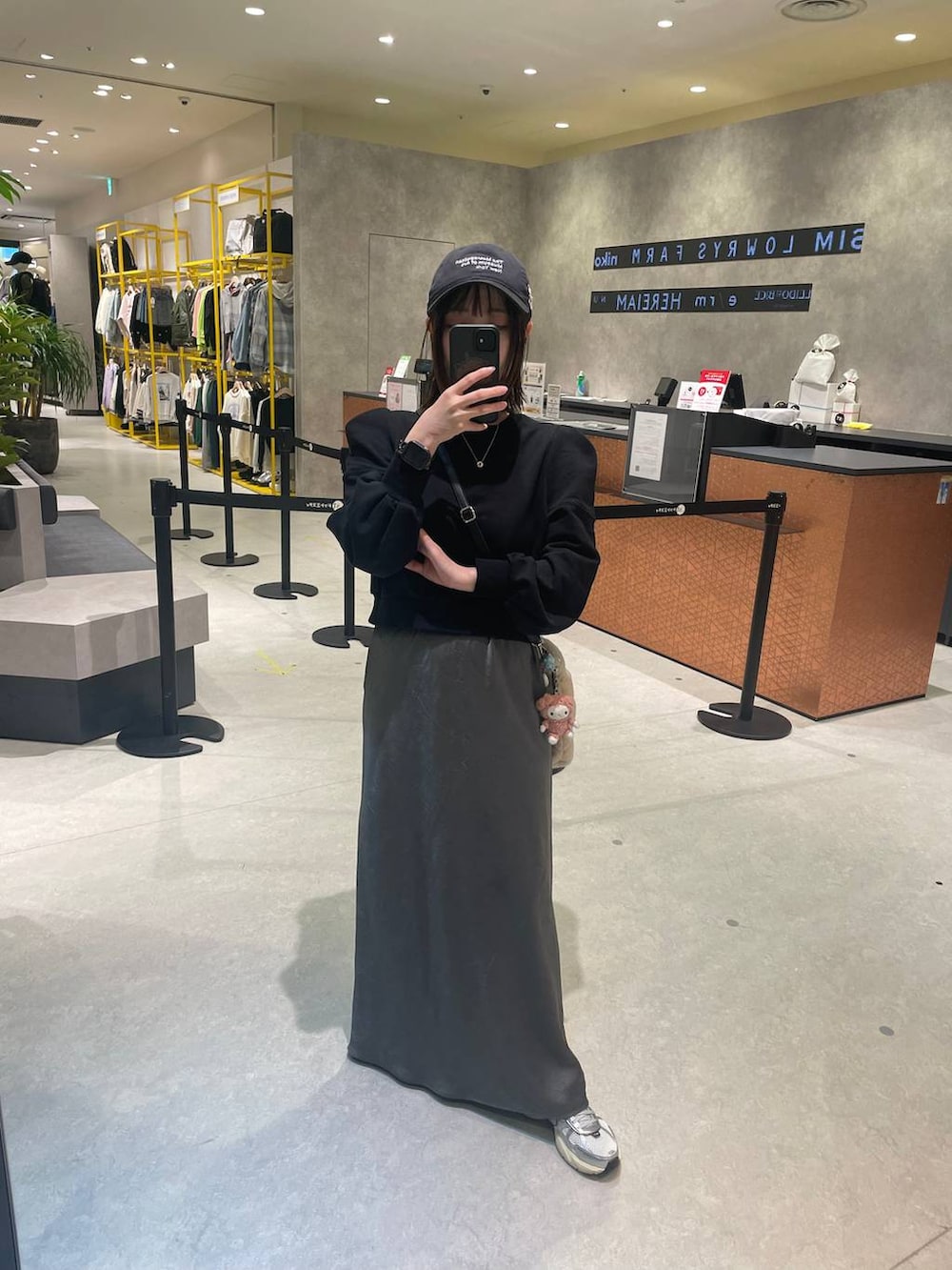 グレー系のスカート、ブラック系のスウェットを着用したレディースの秋コーディネートの4枚目の写真