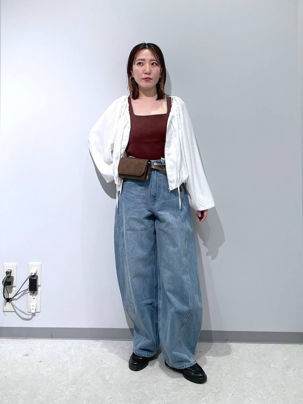 ブルー系のデニムパンツ、ブラウン系のボディバッグ/ウエストポーチ、ブラウン系のタンクトップを着用したレディースの春コーディネートの4枚目の写真