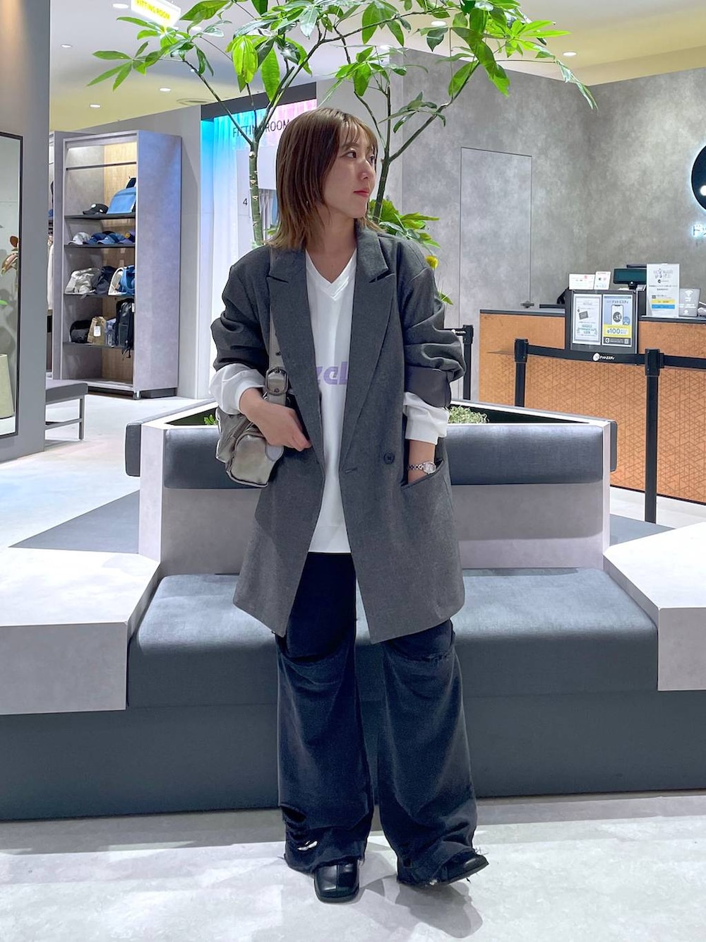 シルバー系のショルダーバッグ、ブラック系のブーツ、ブラック系のスウェットパンツを着用したレディースの秋コーディネートの3枚目の写真