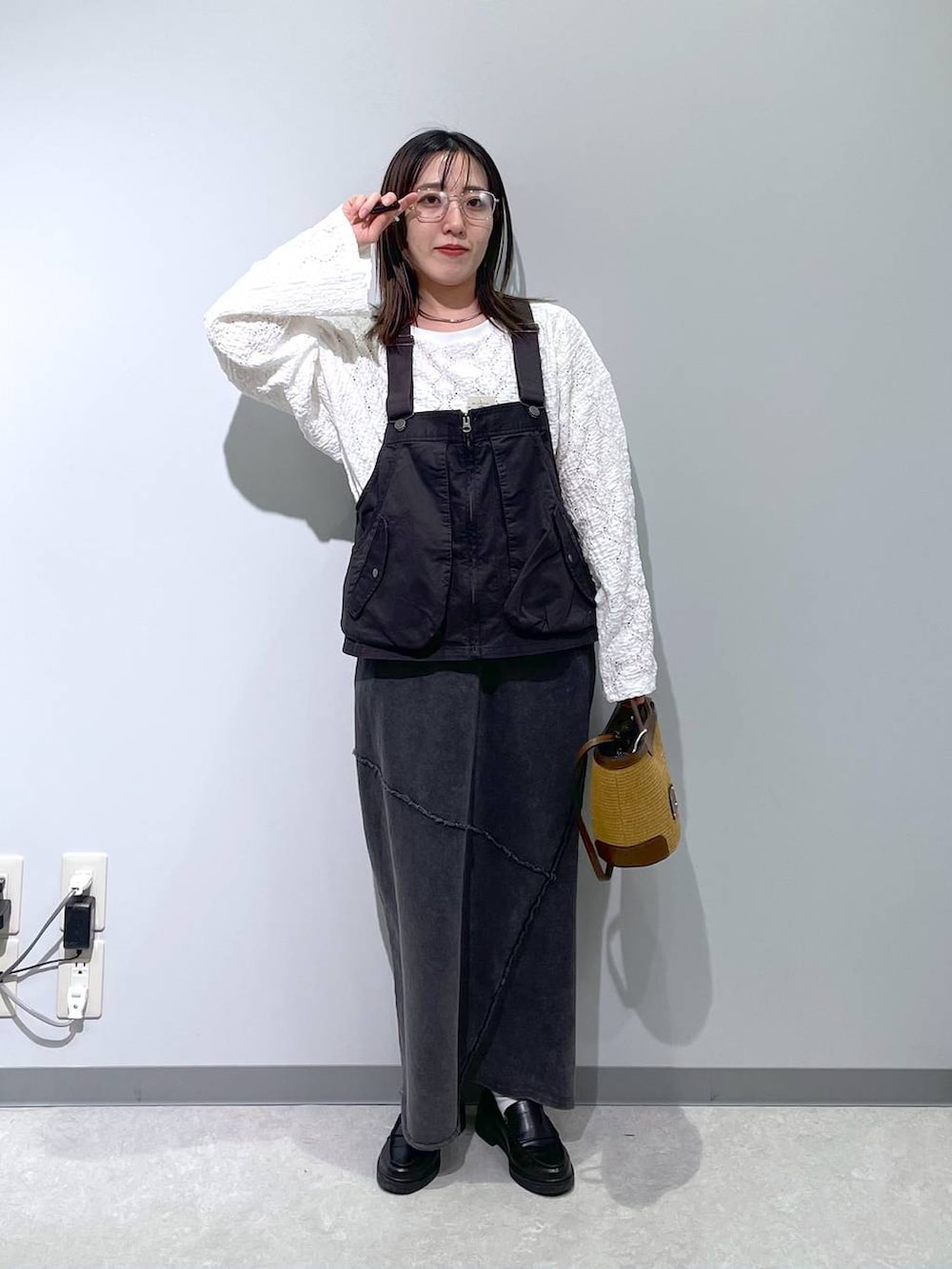 グレー系のベスト、ブラック系のスカート、ホワイト系のTシャツ/カットソーを着用したレディースの春コーディネートの2枚目の写真