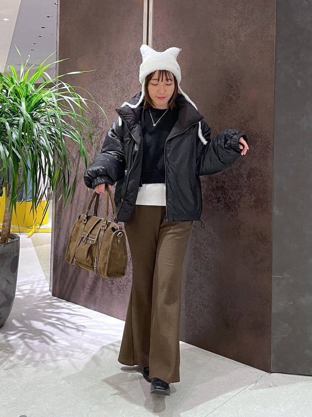 ブラウン系のボストンバッグ、ブラウン系のその他パンツ、ブラック系のブルゾンを着用したレディースの秋コーディネートの3枚目の写真