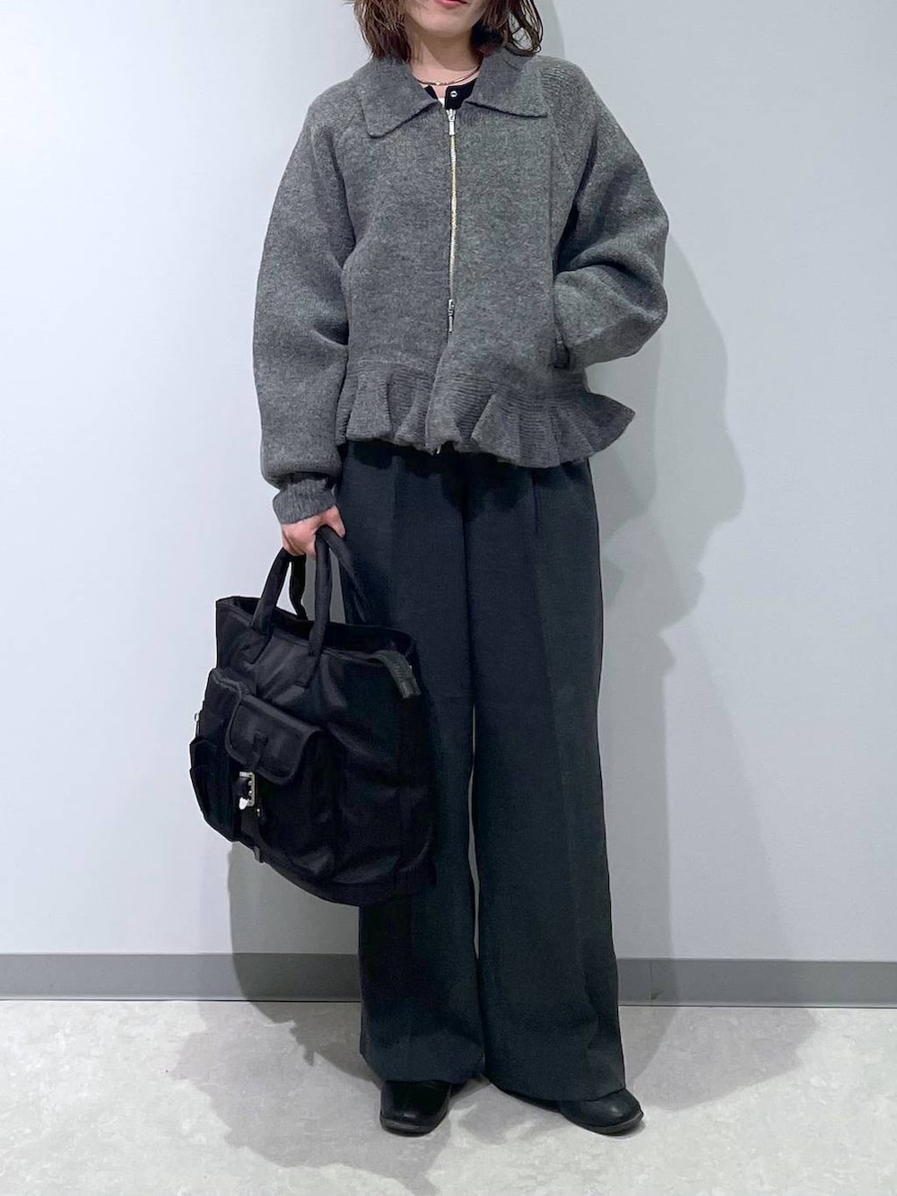 ブラック系のトートバッグ、グレー系のブルゾンを着用したレディースの冬コーディネートの3枚目の写真