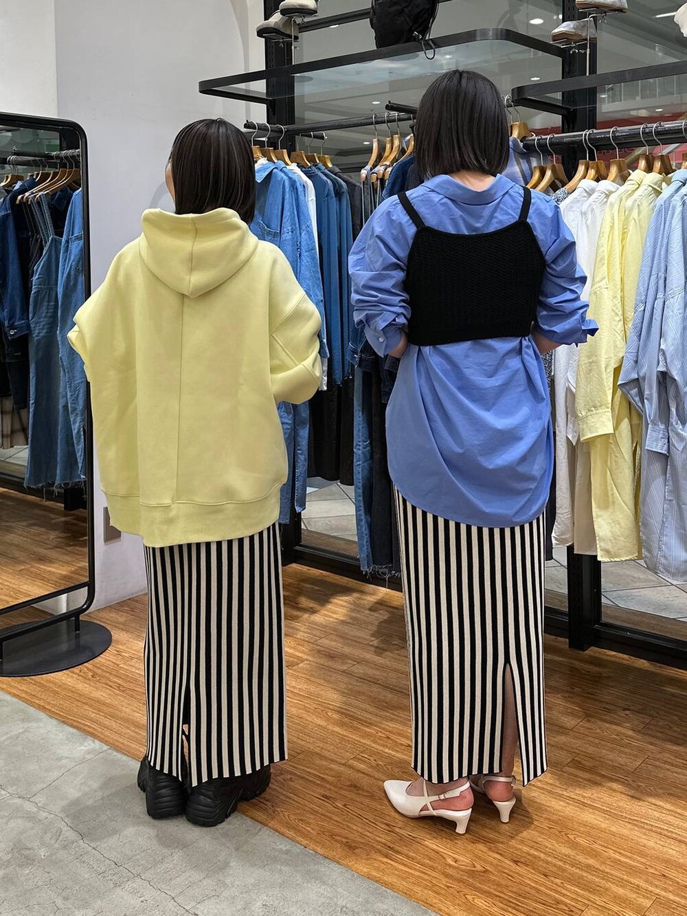 ブルー系のシャツ/ブラウス、ブラック系のニット/セーター、イエロー系のパーカーを着用したレディースの春コーディネートの3枚目の写真