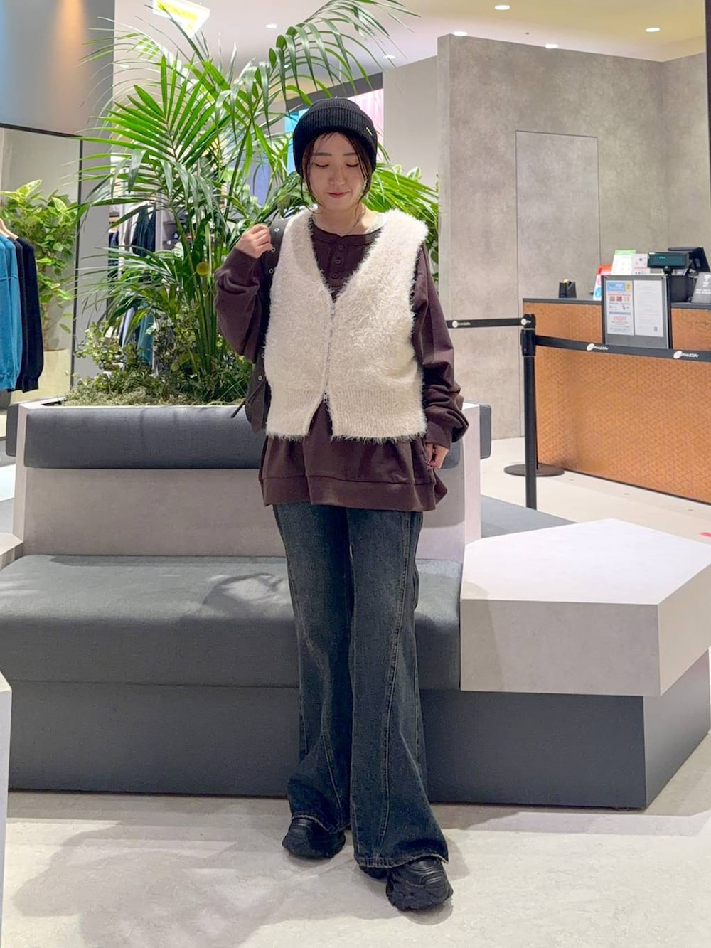 ブラウン系のショルダーバッグ、ブラウン系のスウェット、ブルー系のデニムパンツを着用したレディースの秋コーディネートの3枚目の写真