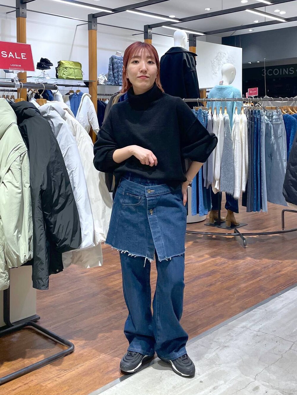 ブラック系のニット/セーター、ブルー系のデニムパンツを着用したレディースの冬コーディネートの3枚目の写真