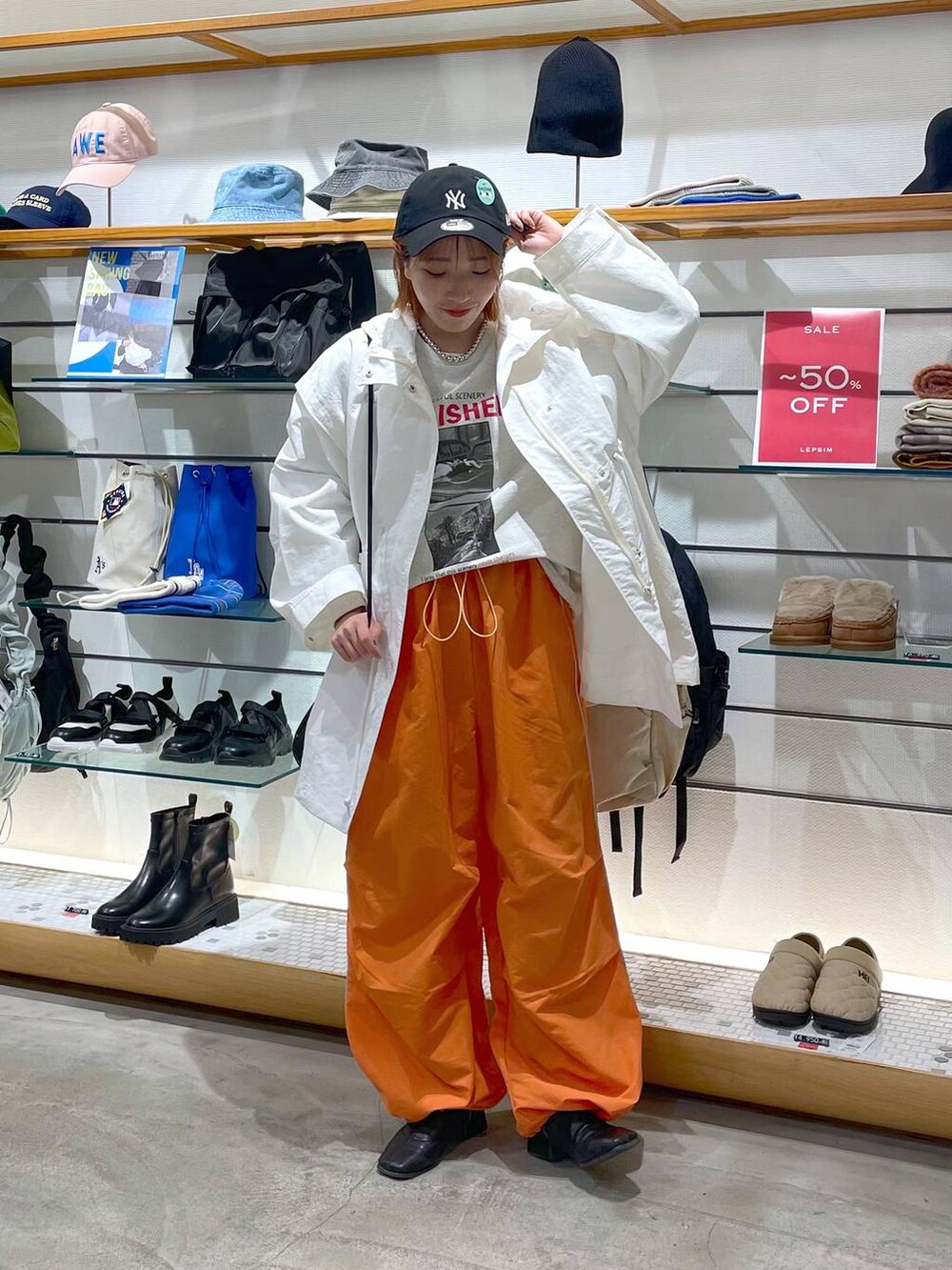 オレンジ系のその他パンツ、ホワイト系のその他アウター、グレー系のTシャツ/カットソーを着用したレディースの春コーディネートの2枚目の写真