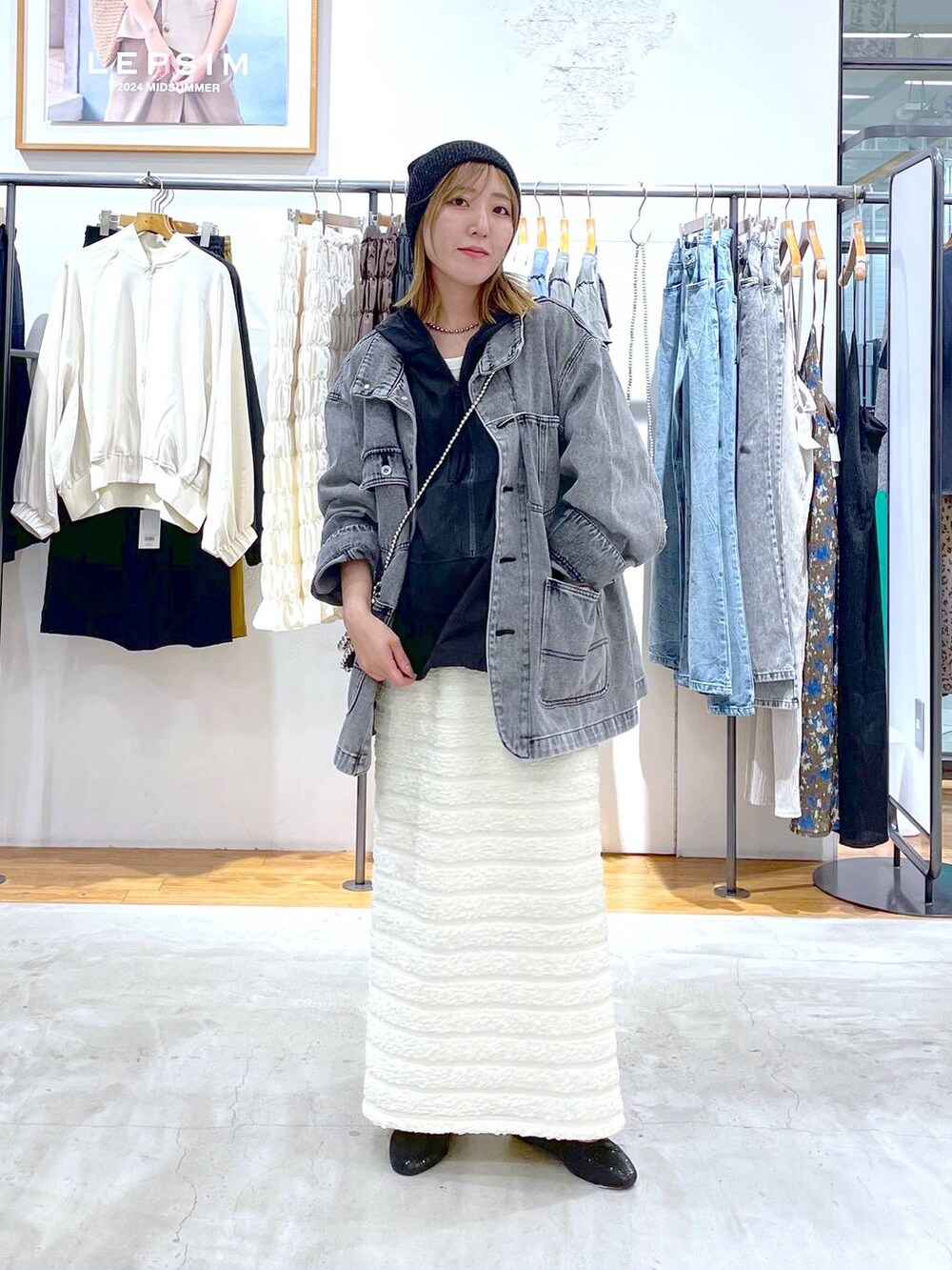 シルバー系のショルダーバッグ、グレー系のデニムジャケット、ブラック系のバレエシューズを着用したレディースの秋コーディネートの3枚目の写真