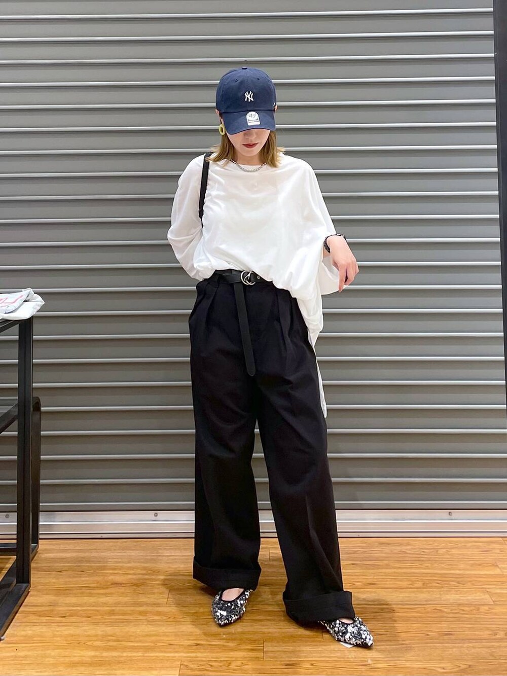 ブラック系のショルダーバッグ、グレー系のチノパンツ、シルバー系のパンプスを着用したレディースの秋コーディネートの2枚目の写真