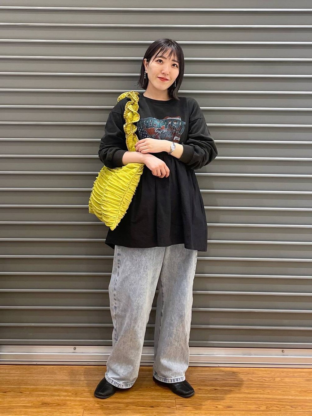 イエロー系のトートバッグ、ブルー系のデニムパンツ、グレー系のTシャツ/カットソーを着用したレディースの春コーディネートの2枚目の写真