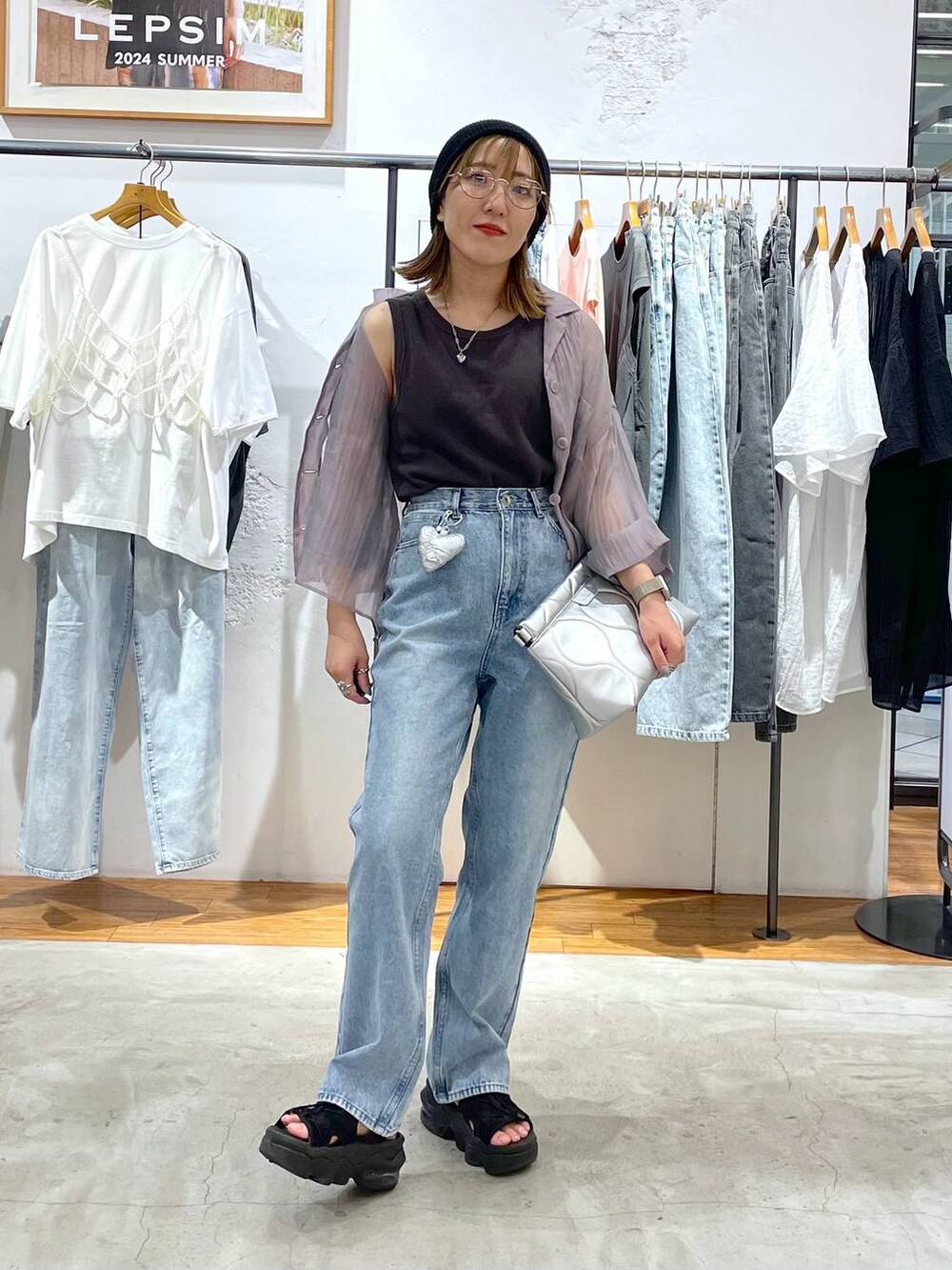 パープル系のシャツ/ブラウス、シルバー系のクラッチバッグ、グレー系のタンクトップを着用したレディースの夏コーディネートの2枚目の写真
