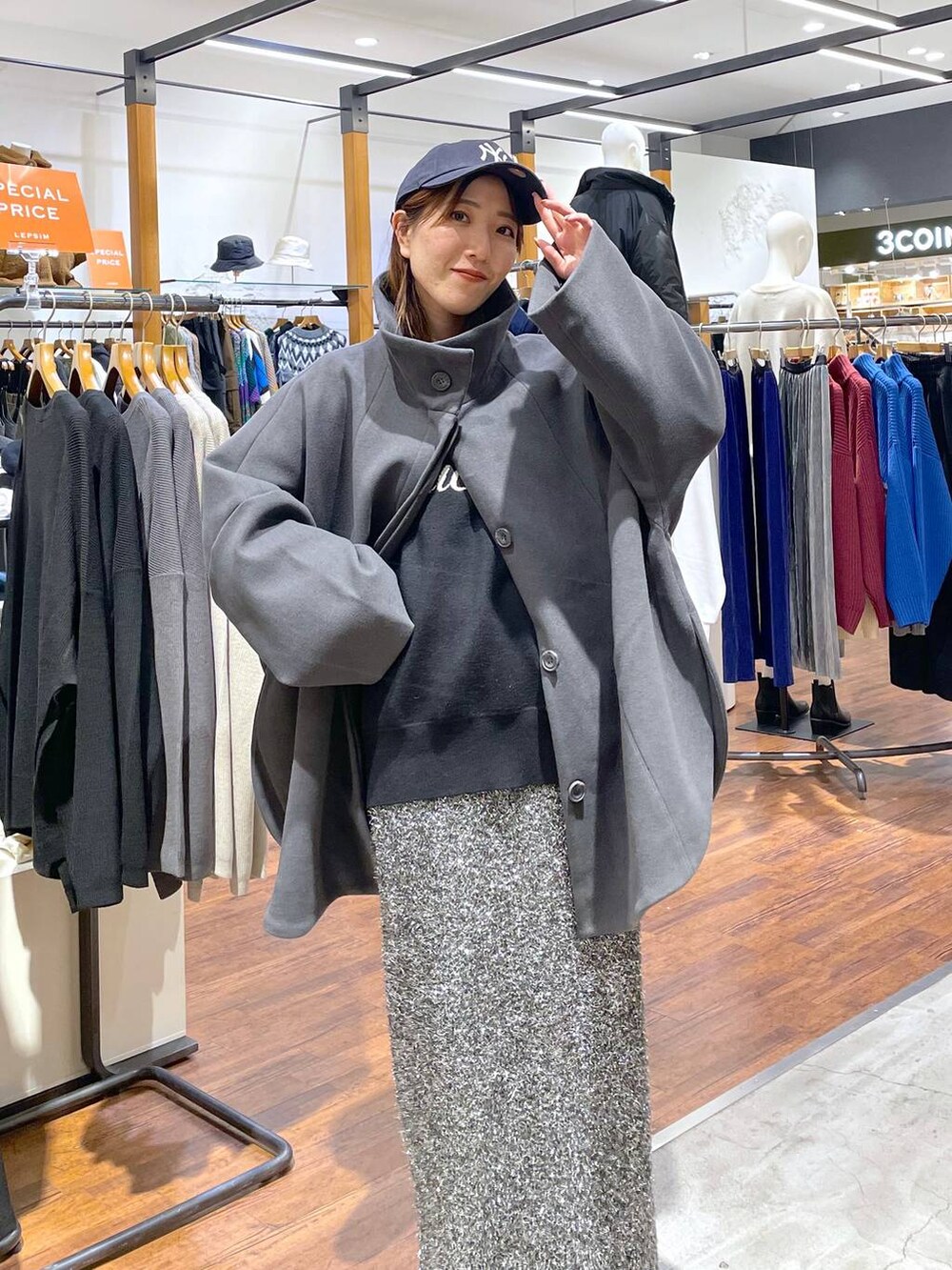 グレー系のポンチョ、ブラック系のニット/セーター、ブラック系のスカートを着用したレディースの冬コーディネートの3枚目の写真