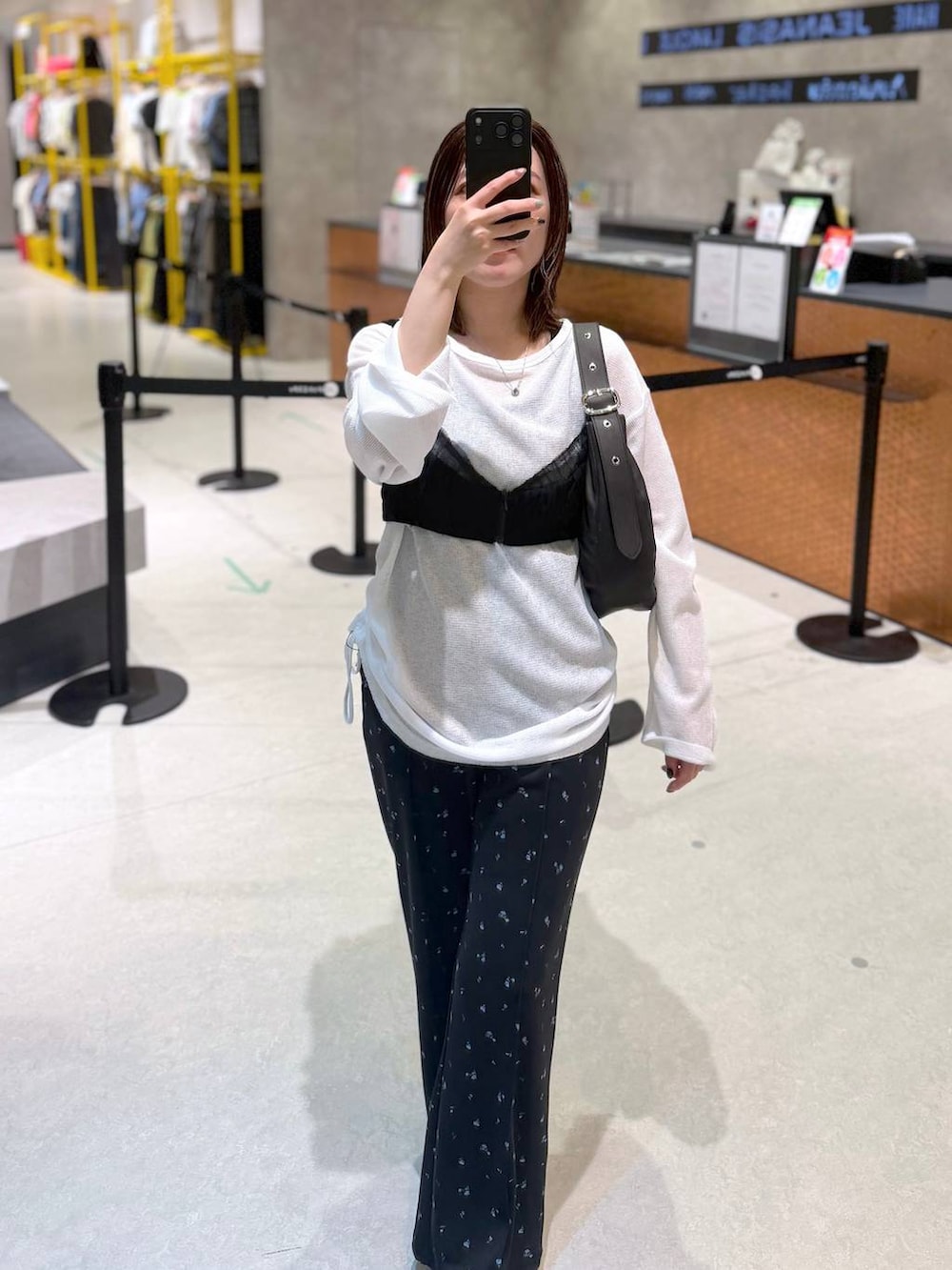 ブラック系のキャミソール、ブラック系のショルダーバッグ、ホワイト系のTシャツ/カットソーを着用したレディースの夏コーディネートの2枚目の写真
