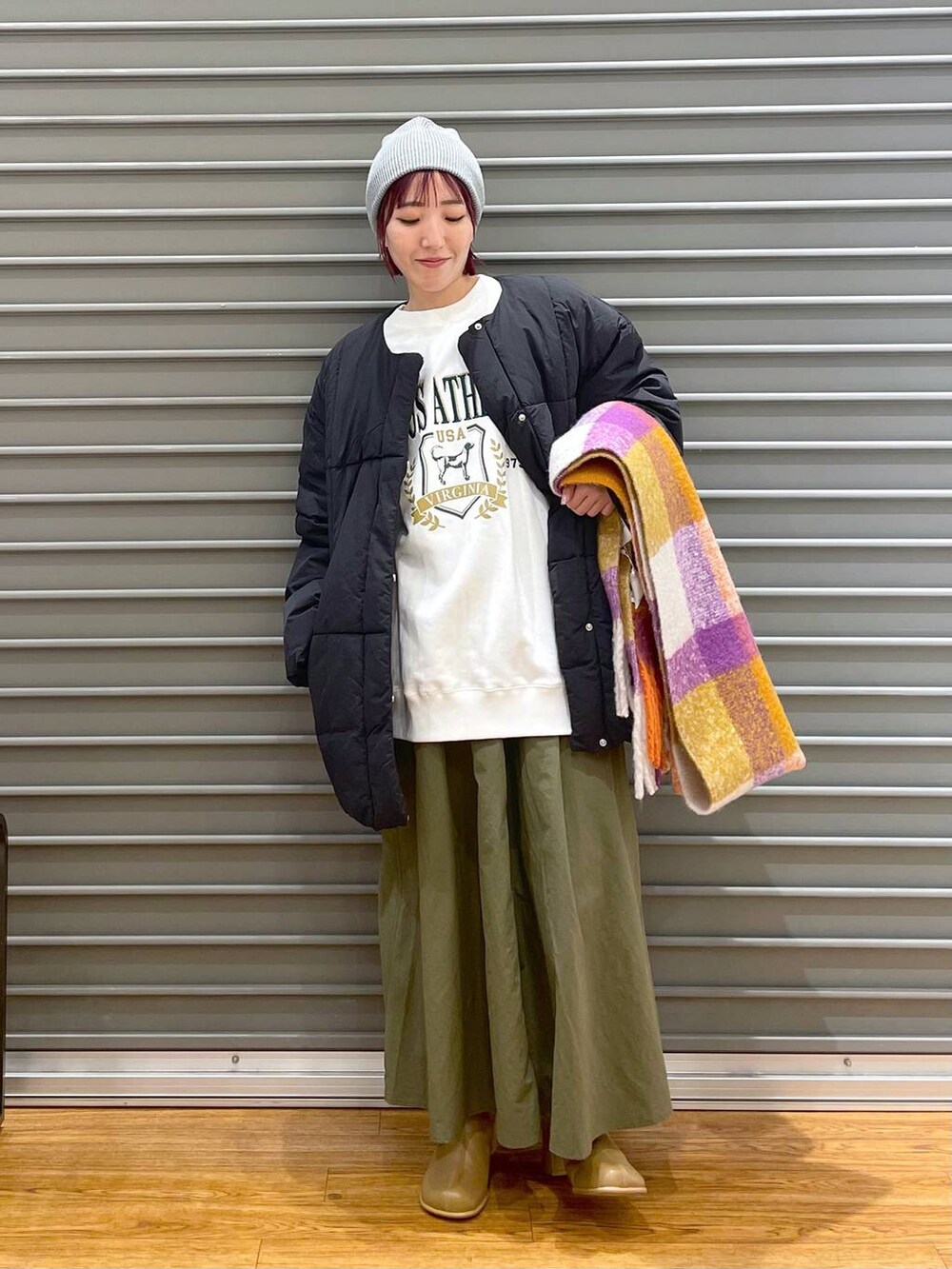 ホワイト系のスウェット、ブラウン系のブーツ、ブラック系のその他アウターを着用したレディースの冬コーディネートの2枚目の写真