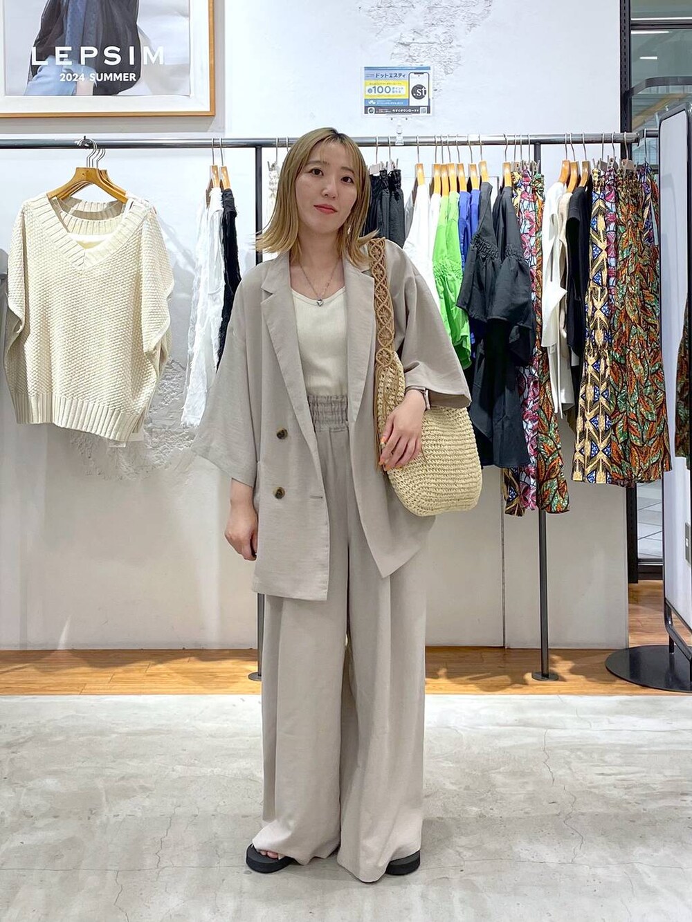 ベージュ系のその他パンツ、ベージュ系のテーラードジャケット、ホワイト系のタンクトップを着用したレディースの夏コーディネートの2枚目の写真