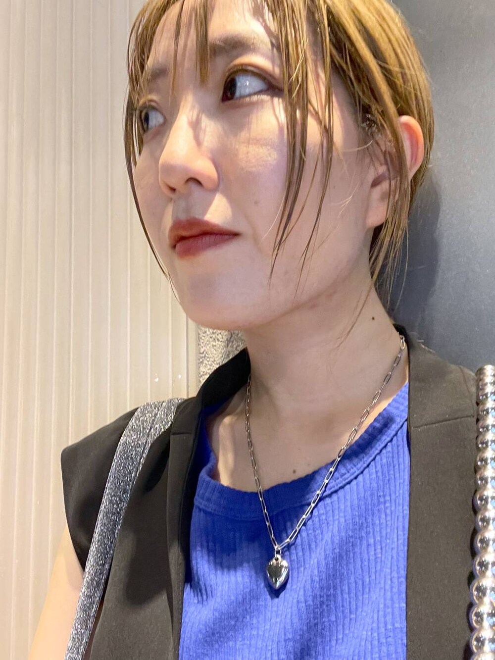 ブラック系のスラックス、シルバー系のスマホグッズを着用したレディースの夏コーディネートの2枚目の写真