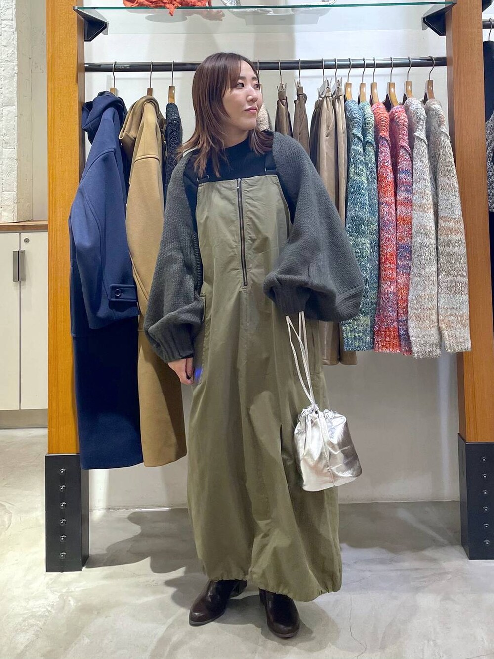 ブラック系のニット/セーター、グレー系のカーディガン/ボレロ、ブラウン系のブーツを着用したレディースの冬コーディネートの2枚目の写真