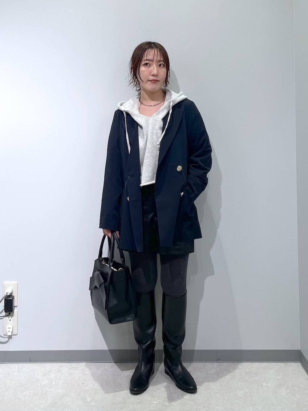 ブラック系のその他パンツ、ブルー系のテーラードジャケット、ブラック系のハンドバッグを着用したレディースの冬コーディネートの3枚目の写真