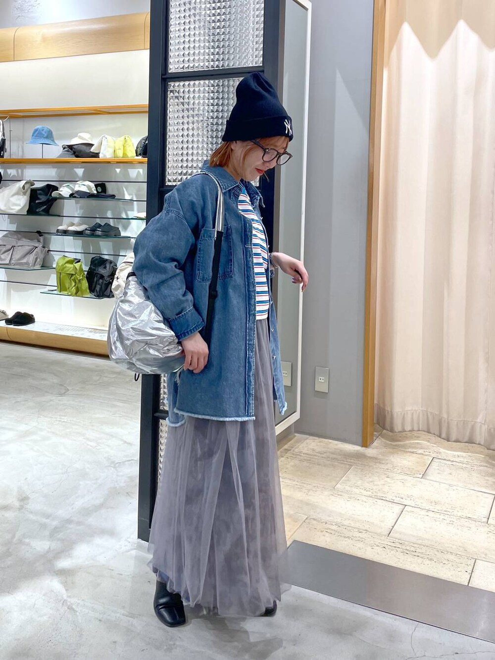 シルバー系のショルダーバッグ、ホワイト系のスカート、ブルー系のシャツ/ブラウスを着用したレディースの春コーディネートの2枚目の写真