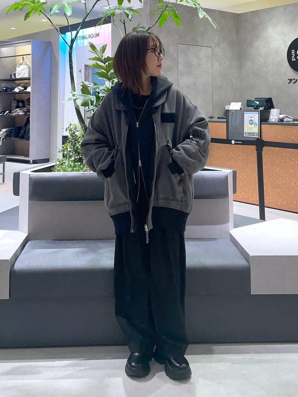 グレー系のブルゾン、ブラック系のスラックス、ブラック系のTシャツ/カットソーを着用したレディースの冬コーディネートの2枚目の写真