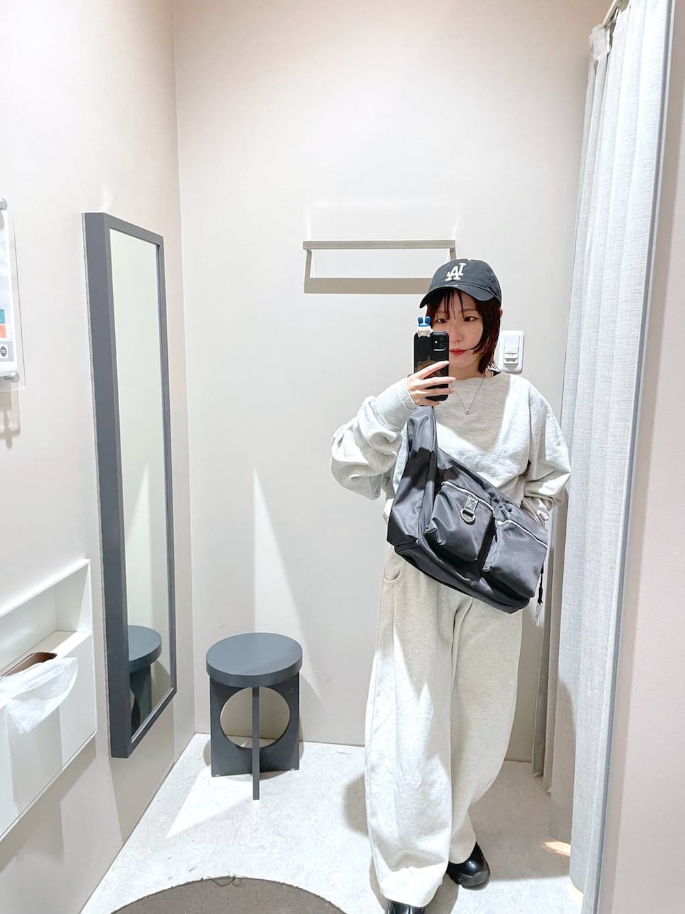 グレー系のショルダーバッグ、グレー系のスウェット、ベージュ系のスウェットパンツを着用したレディースの冬コーディネートの3枚目の写真