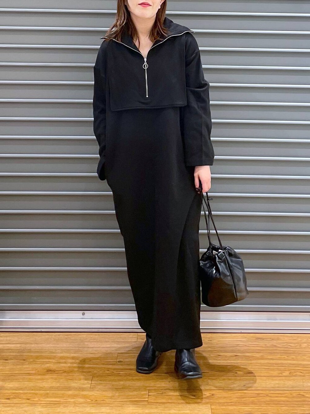 ブラック系のワンピース、ブラック系のショルダーバッグを着用したレディースの冬コーディネートの3枚目の写真