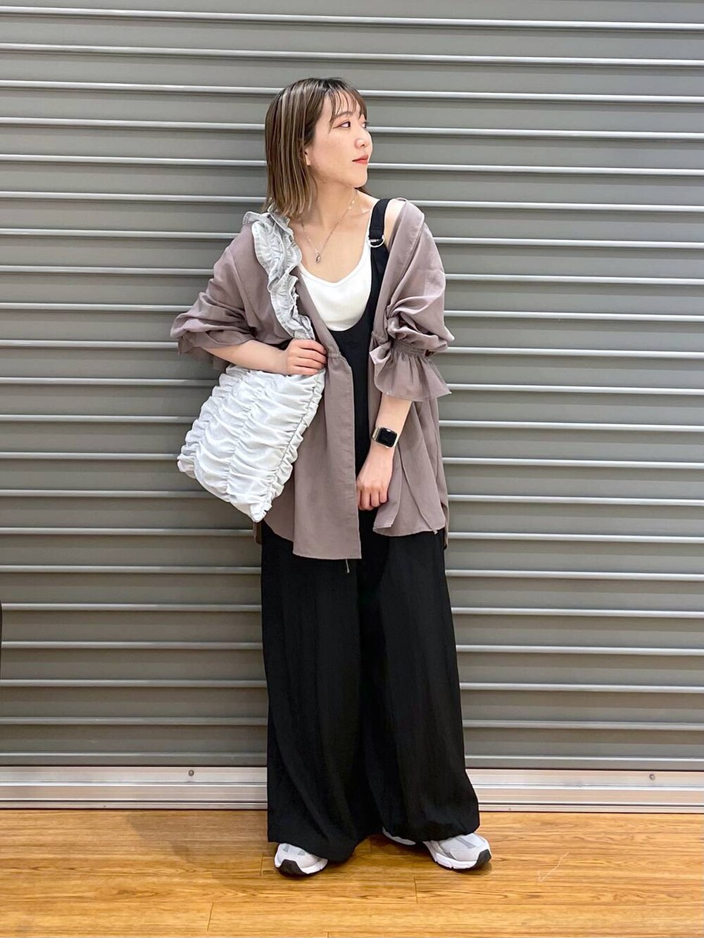 グレー系のスニーカー、シルバー系のトートバッグ、ブラウン系のシャツ/ブラウスを着用したレディースの春コーディネートの2枚目の写真