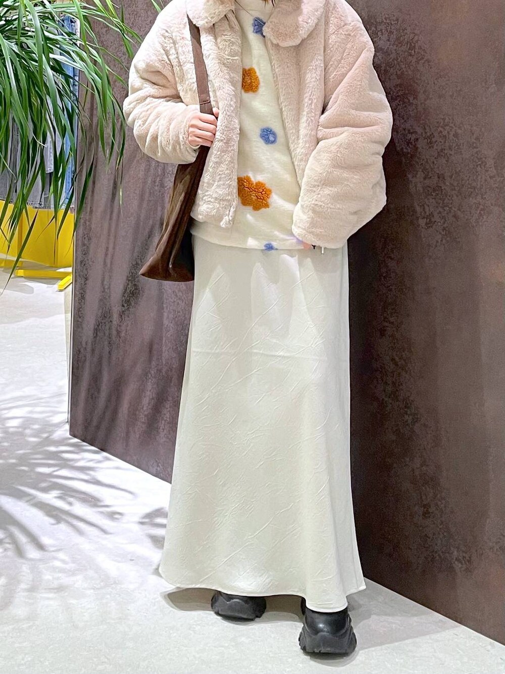 ブラウン系のショルダーバッグ、ホワイト系のスカート、ホワイト系のブルゾンを着用したレディースの冬コーディネートの3枚目の写真