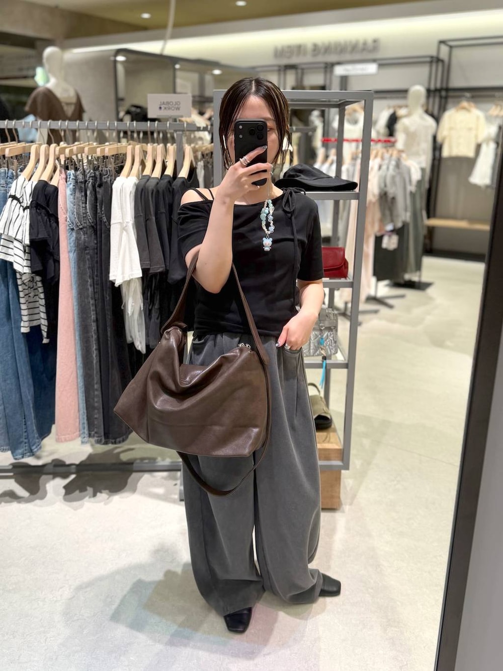ブラウン系のショルダーバッグ、グレー系のスウェットパンツ、ブラック系のTシャツ/カットソーを着用したレディースの夏コーディネートの3枚目の写真