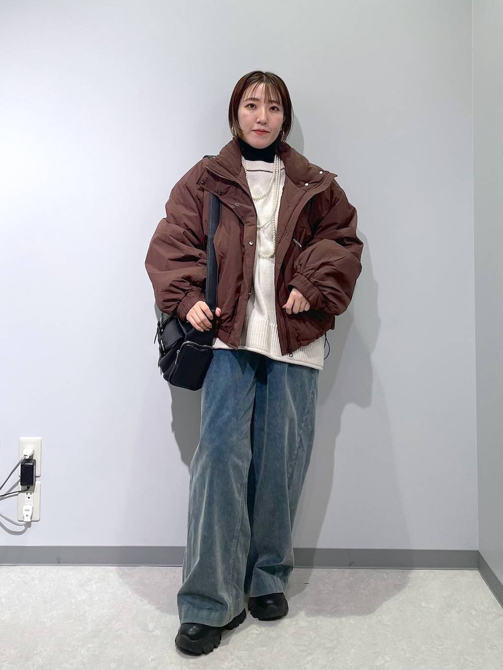 ブラウン系のその他アウター、ブラック系のニット/セーター、ブルー系のその他パンツを着用したレディースの冬コーディネートの4枚目の写真