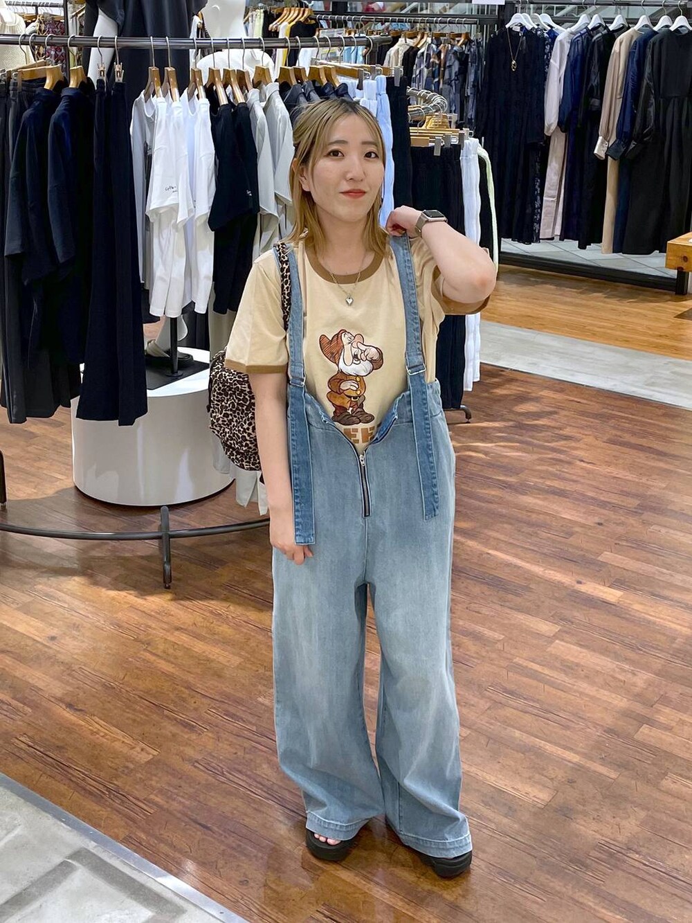 ブルー系のデニムパンツ、ブラック系のショルダーバッグ、グリーン系のTシャツ/カットソーを着用したレディースの夏コーディネートの2枚目の写真