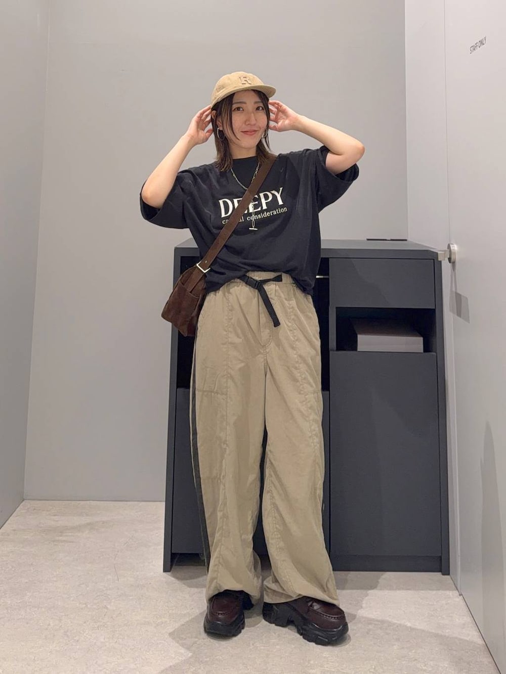 ブラック系のTシャツ/カットソー、ブラウン系のローファー、ブラウン系のその他パンツを着用したレディースの夏コーディネートの2枚目の写真