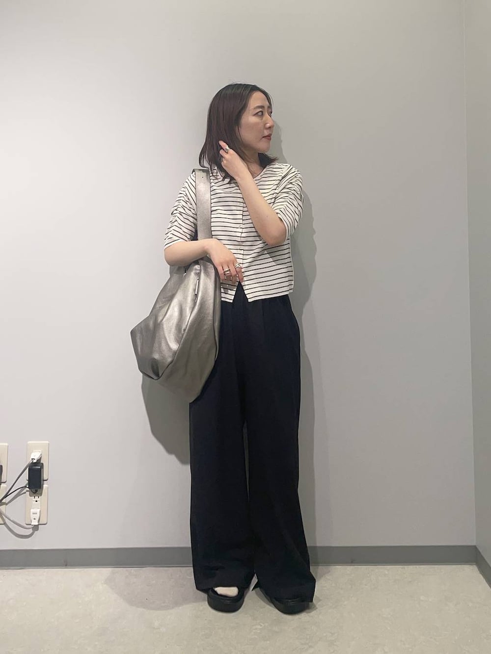 ブラック系のその他パンツ、ブラック系のサンダル、シルバー系のショルダーバッグを着用したレディースの春コーディネートの2枚目の写真
