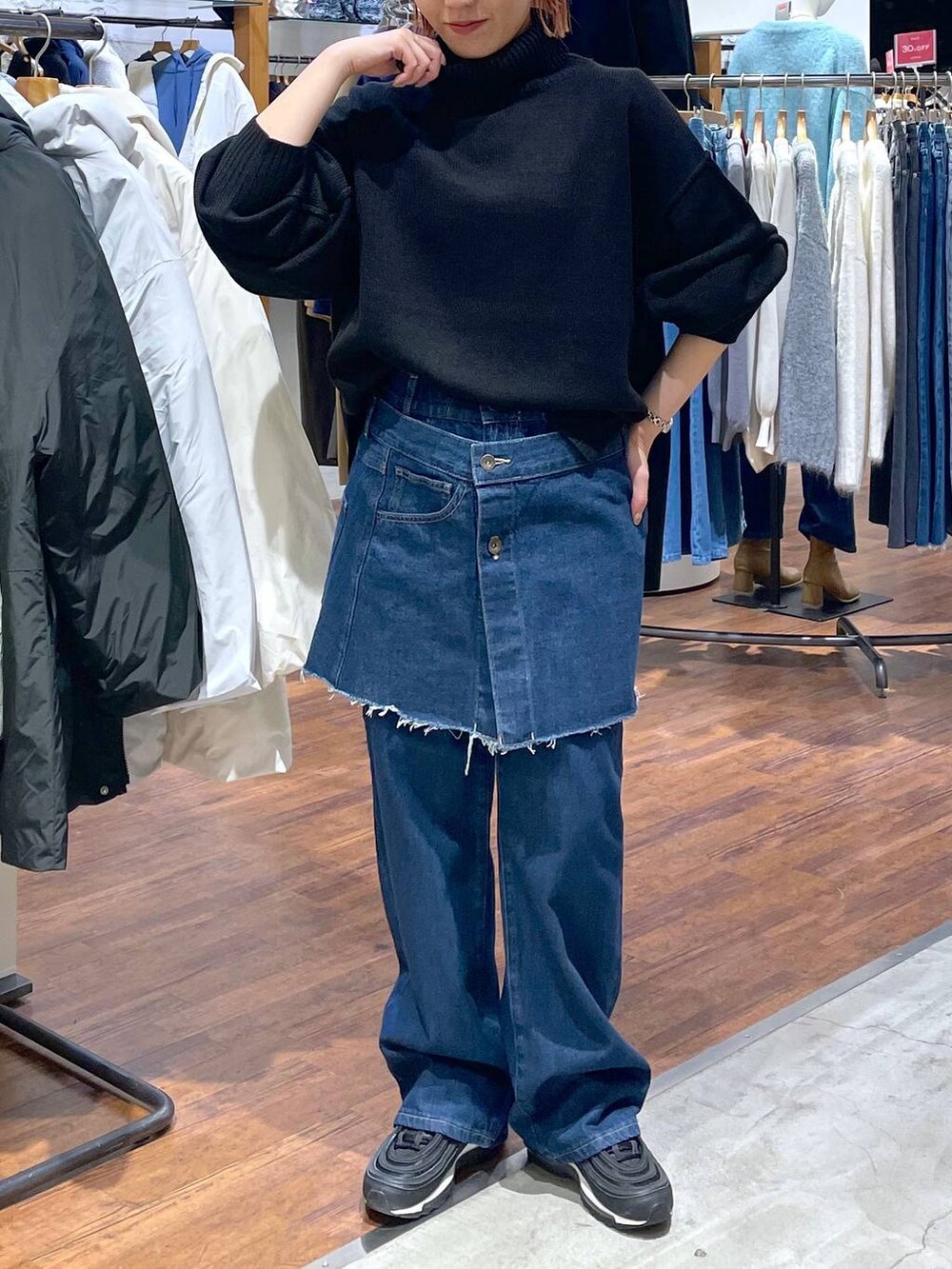 ブラック系のニット/セーター、ブルー系のデニムパンツを着用したレディースの冬コーディネートの2枚目の写真