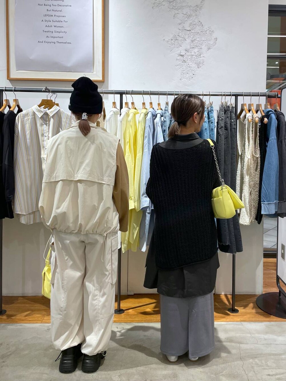 イエロー系のショルダーバッグ、ホワイト系のベスト、ベージュ系のTシャツ/カットソーを着用したレディースの春コーディネートの2枚目の写真