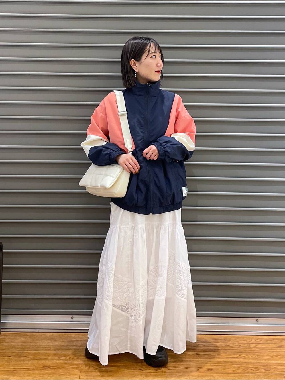 ホワイト系のショルダーバッグ、ブルー系のブルゾン、ホワイト系のワンピースを着用したレディースの春コーディネートの2枚目の写真