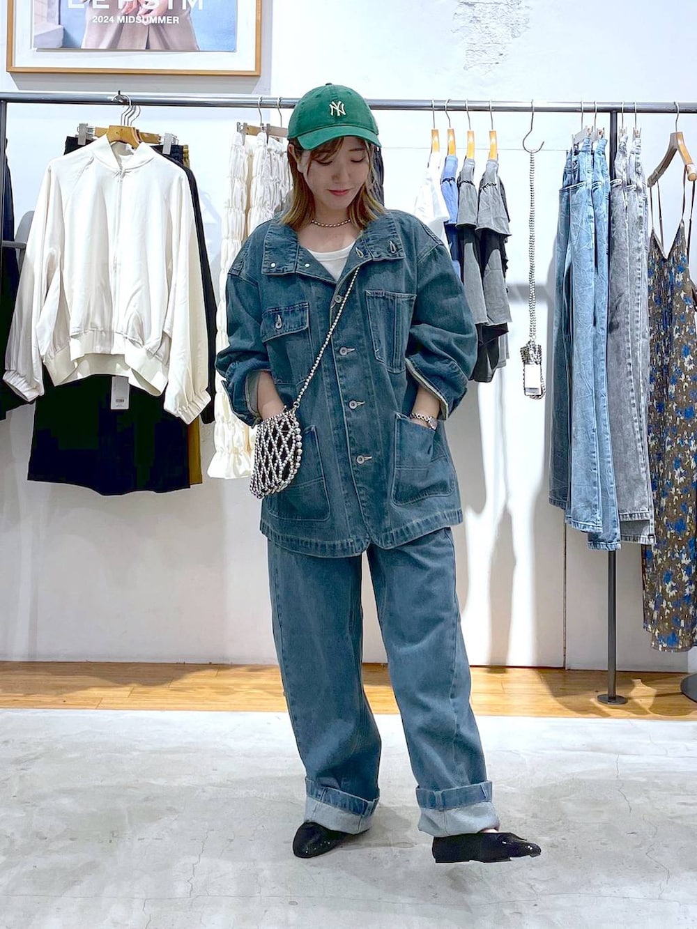 シルバー系のショルダーバッグ、ブルー系のデニムジャケット、ブラック系のバレエシューズを着用したレディースの秋コーディネートの3枚目の写真