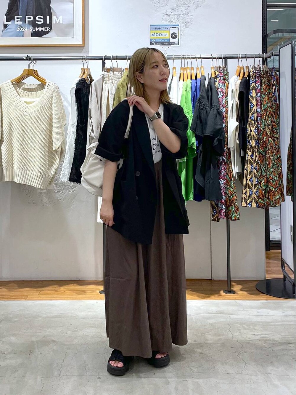 ブラック系のテーラードジャケット、ホワイト系のTシャツ/カットソー、ホワイト系のショルダーバッグを着用したレディースの夏コーディネートの2枚目の写真