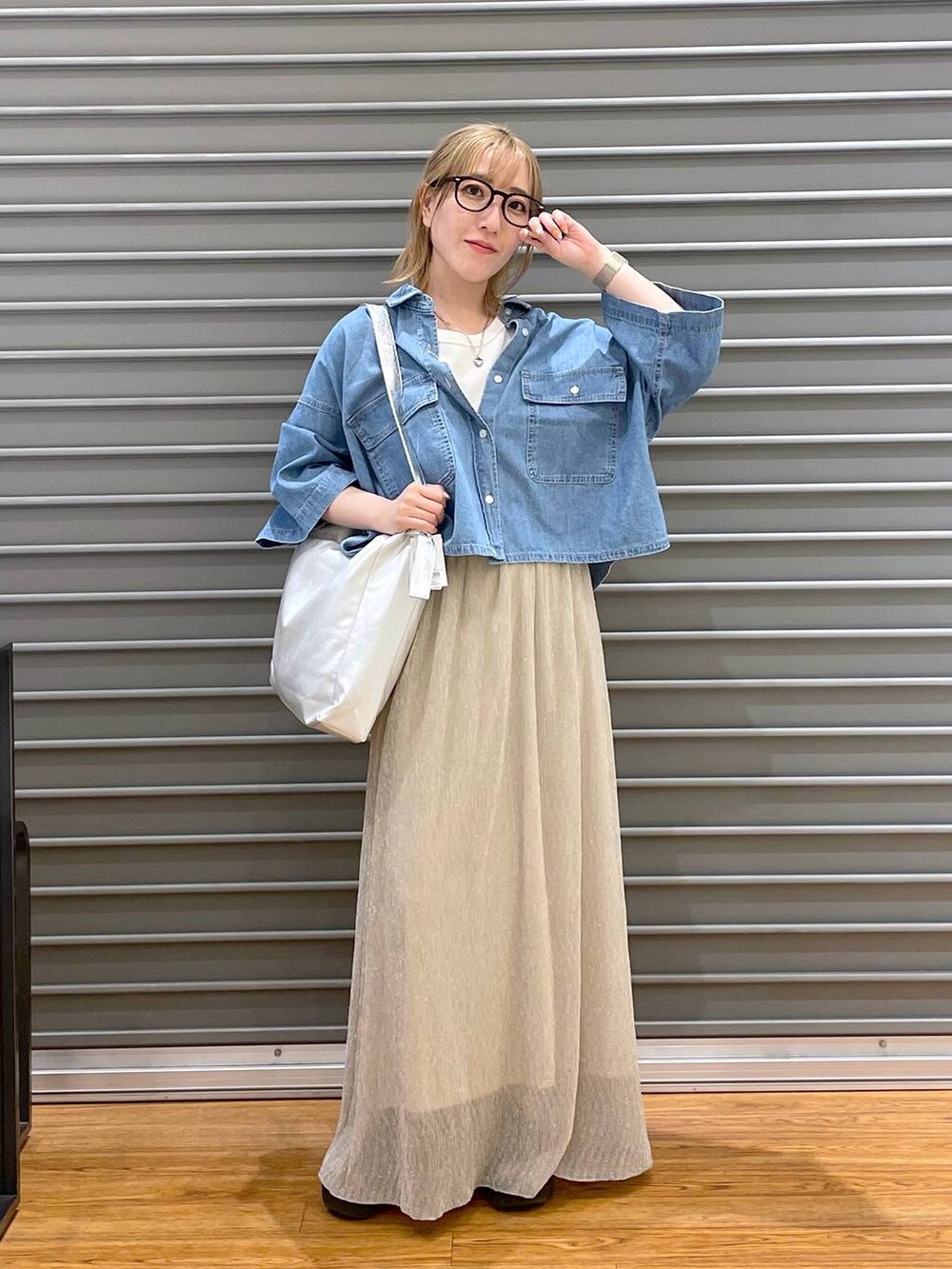 ホワイト系のTシャツ/カットソー、ブルー系のシャツ/ブラウス、シルバー系のショルダーバッグを着用したレディースの春コーディネートの2枚目の写真