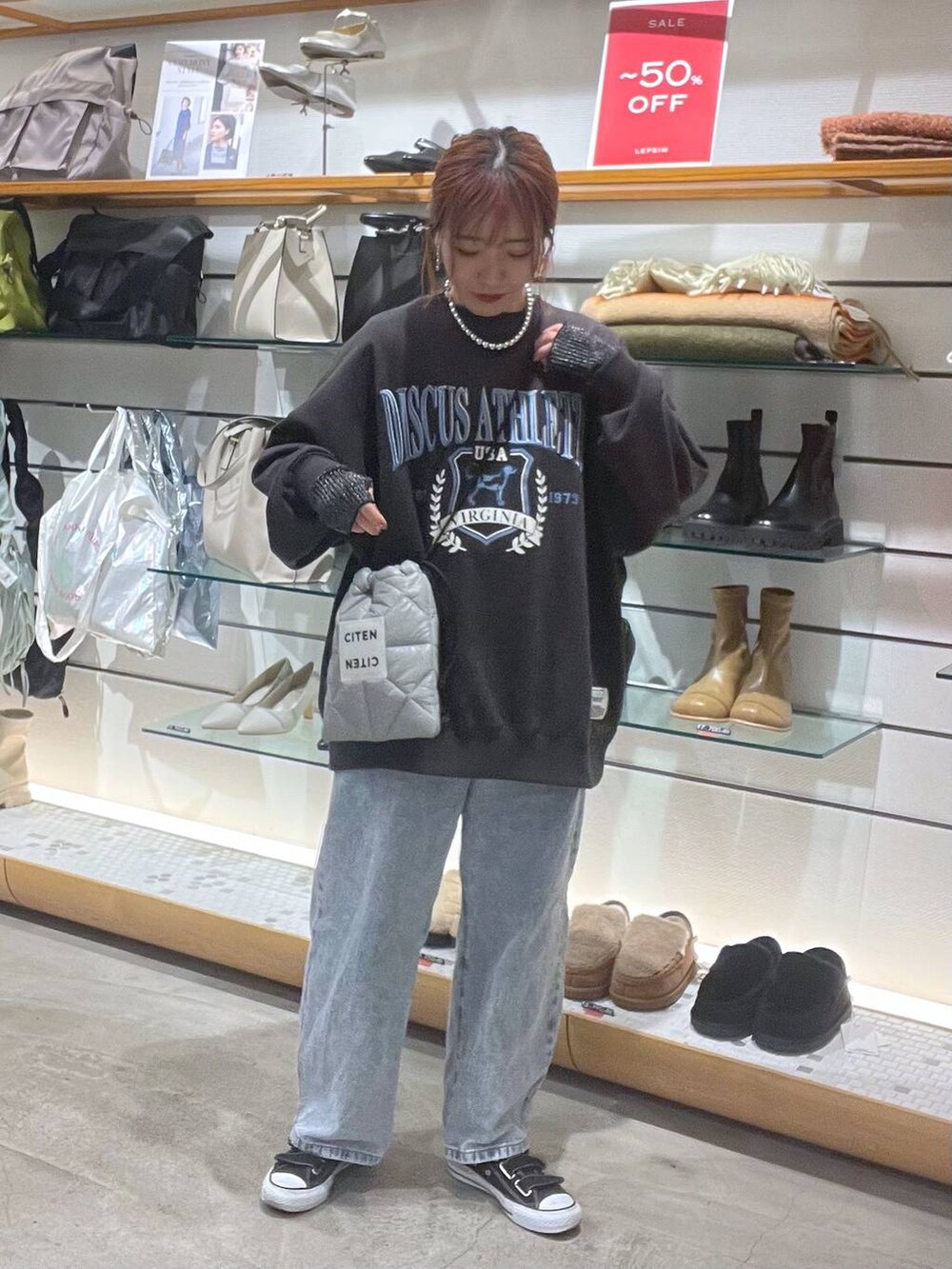 グレー系のスウェット、ブルー系のデニムパンツを着用したレディースの冬コーディネートの5枚目の写真