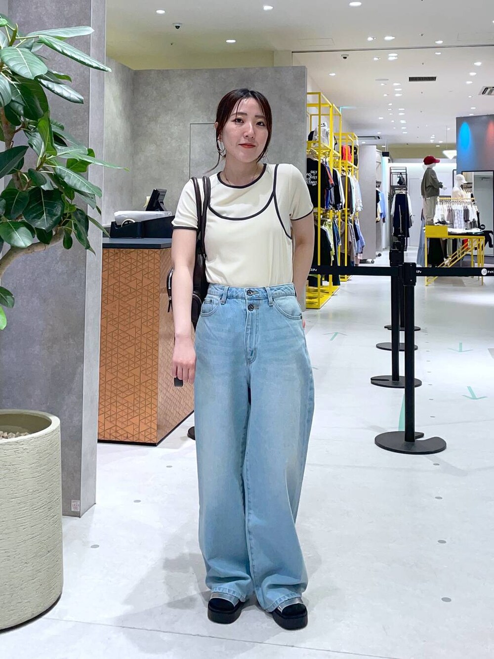ブラウン系のボストンバッグ、シルバー系のサンダル、ベージュ系のTシャツ/カットソーを着用したレディースの春コーディネートの2枚目の写真