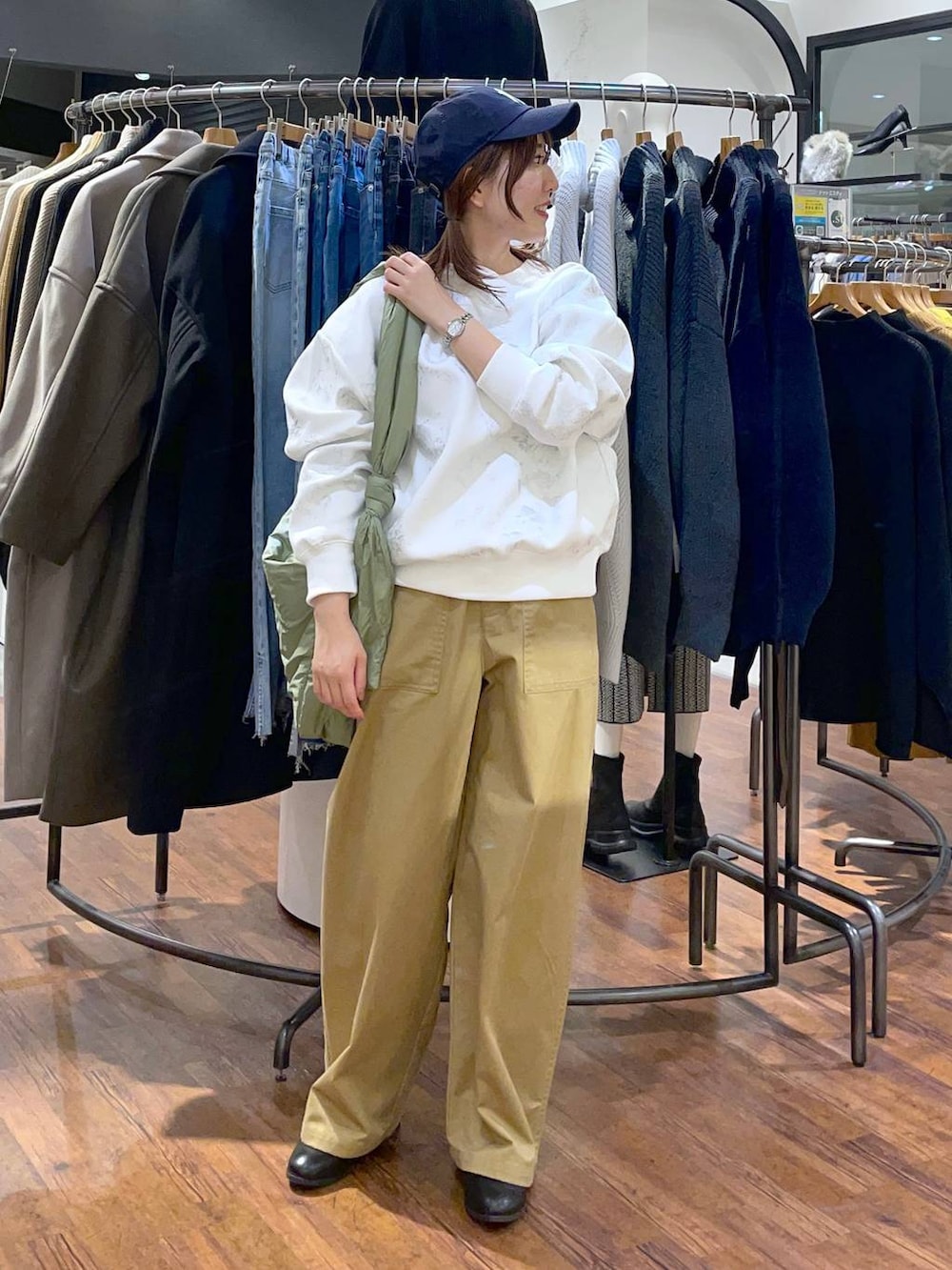 ベージュ系のその他パンツ、グリーン系のショルダーバッグ、ホワイト系のスウェットを着用したレディースの冬コーディネートの2枚目の写真