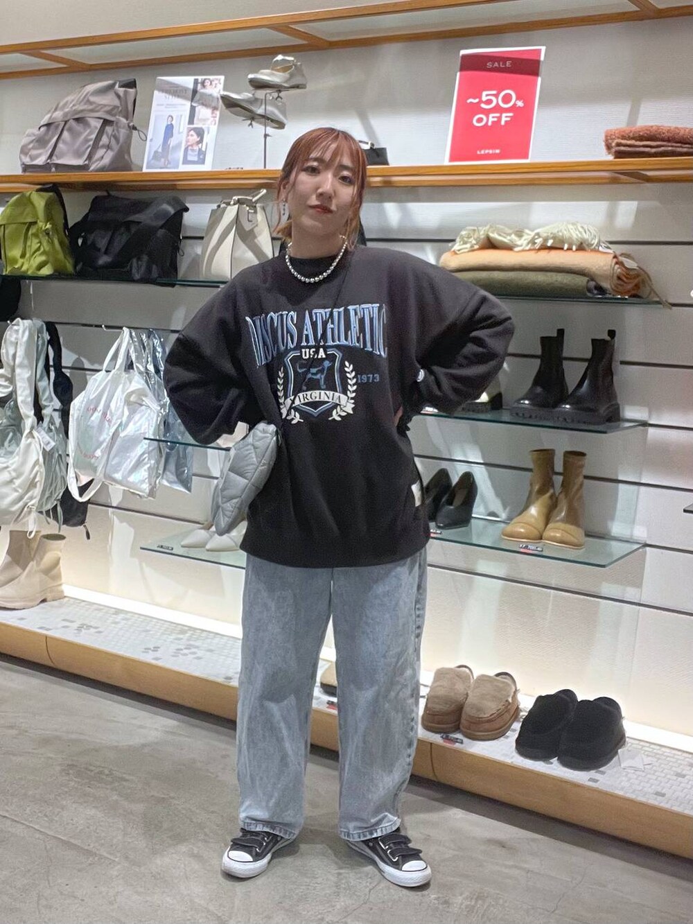 グレー系のスウェット、ブルー系のデニムパンツを着用したレディースの冬コーディネートの2枚目の写真